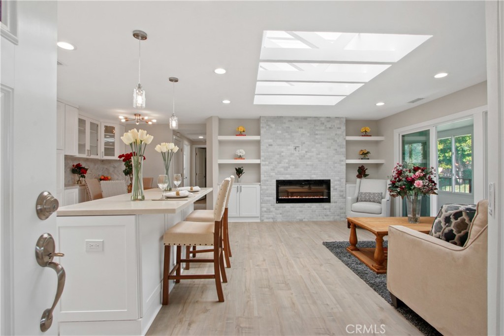 RENOVATED COOP! A recently renovated two bedroom, two bathroom home is now available and located in Laguna Woods Village, an HOA managed 55+ community within South Orange County, CA. NO EXPENSE WAS SPARED during the renovation of this popular "Casa Linda" floor plan. The home is ground floor/street level with no stairs leading to and from the nearby carport. The home features new plank style flooring along with premium tile/stone upgrades throughout. The upgraded kitchen features premium white shaker style cabinetry and includes stainless steel appliances. The living room has a massive skylight with exposed truss work and a custom built-in entertainment center with an electronic fireplace and is pre-wired for flat screen TV mounting. The master bedroom includes a walk-in closet, a private master bathroom with a generously size shower and floating bench. The guest bedroom features balcony access and a guest bath with a skylight for added natural sunlight. The home includes a stacked washer/ dryer and a recently installed central heating and cooling system. There is also a private enclosed balcony overlooking the neighborhood. There is a detached carport (#456-5) a short walk from the home and ample public parking spaces nearby. Laguna Woods Village is a thriving community with many activities to enrich your lifestyle! The monthly HOA includes property taxes, utilities (water, trash, cable TV), and maintenance of exteriors. *Unit is virtually staged.