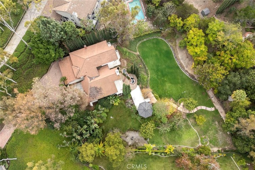 Discover one of the most breathtaking and surreal locations to hit the market in the highly sought-after Canyon Hills Estates! Nestled in serene seclusion, this privately situated sanctuary rests gracefully upon nearly an acre of lush, living landscape — a tranquil retreat embraced by rustling trees and layers of greenery. A long, meandering paver driveway leading to the stone courtyard takes you away from the city life and welcomes you home. Beyond the double doors, get ready for the jaw dropping open great room with conversation space framed in soft arched lines and warming fireplace and custom finished office, perfect for mindful creation and reflection. Walls of French-pane windows and doors invite in the rhythm of light and the rustle of nature, while multi-toned wood plank floors lend a grounded warmth to the formal living and dining areas. GET READY FOR THE ULTIMATE IN CULINARY EXPERIENCES with this unbelievable commercial kitchen that puts most restaurants to shame. Seating for 16 around U shaped island bar done with underlit onyx, built in stainless serving station and full Hibachi grill! The kitchen was designed for artistry and function with every professional grade cooking appliance you can think of. The dining experience then takes on a whole other level with a dedicated coffee station with built in espresso and an ice cream parlor. The kitchen opens seamlessly to the family room, where energy flows easily, and to a large open dining room. Ascending the stairs, the primary suite unfolds like a meditation space — cathedral ceilings lift the spirit, rich wood floors center the senses, and a private deck extends toward the treetops. A raised retreat area offers a moment for stillness, while the spa-inspired bath invites deep restoration with dual vanities, a luxurious soaking tub, and a rain of water from the oversized shower — a cleansing ritual of renewal.  Two additional bedrooms share a beautifully appointed bath, while the lower level reveals a 1,000 sqft self-contained haven — a versatile apartment-style space with a wine cellar, ideal for savoring both solitude and company.  Outside, nature embraces every angle. Rolling lawns, shaded by mature trees, cradle an intimate gazebo and multiple decks designed for reflection, laughter, and the soft exhale of a day well-lived. This home is not merely a residence — it is a sanctuary of presence, harmony, and timeless connection between architecture and nature.