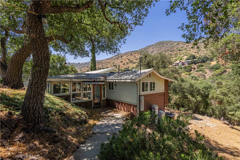This AMAZING property is nestled at the TOP OF THE HILL on an over 5 ACRES LOT surrounded by trees and 360 Degrees CITY LIGHTS VIEWS!!! A true opportunity for developers and investors with potential for subdivision or homeowners to build a spectacular dream home. The main house has living room with stone fireplace and 2 large enclosed patios. This property features one bedroom and one bathroom. There is also a large basement with storage and laundry area. Upgrades included dual pane windows and fully paid solar system. Detached guest house with kitchen, family room, full bath and large loft used for bedroom, perfect for as a rental unit or for extended family living. Huge flat lot has many RV parkings, room for pool/spa, chickens or horses with plenty of room for a training ring. This is ONE OF THE KIND property offering endless possibilities. It is a dream home for someone looking to get away from it and enjoy living in their own private.