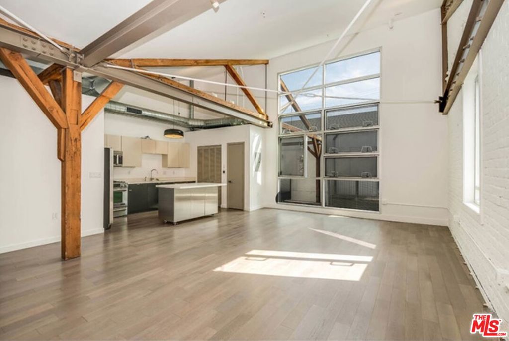 Experience urban living at its finest in this highly sought-after corner end unit at the renowned Barker Block in the Arts District. This stunning open concept loft (no enclosed bedroom) is bathed in natural light through expansive double-pane windows with a motorized shade and boasts soaring vaulted ceilings with exposed beams, a classic brick accent wall, and engineered wood flooring throughout. The spacious kitchen is equipped with stainless steel appliances, ample cabinetry, and generous counter space, while in-unit laundry and abundant closet storage add everyday convenience. Barker Block is known for its exceptional rooftop amenities, featuring a resort-style pool, cabanas, fire pits, BBQ grills, multiple seating areas, and panoramic views of the Downtown LA skyline. Residents also enjoy a fully equipped fitness center and stylish lounge areas throughout the community. This lease includes one secure garage parking space and a small storage unit. Ideally located across from Urth Caffe and Arts District Park, you're just steps from the neighborhood's best dining, shopping, and entertainment, with easy access to freeways and public transit. A rare opportunity in one of DTLA's most desirable addresses, this is a must-see! Tenants responsible to pay for HOA Move-in/Move-out fees + Renters Insurance.