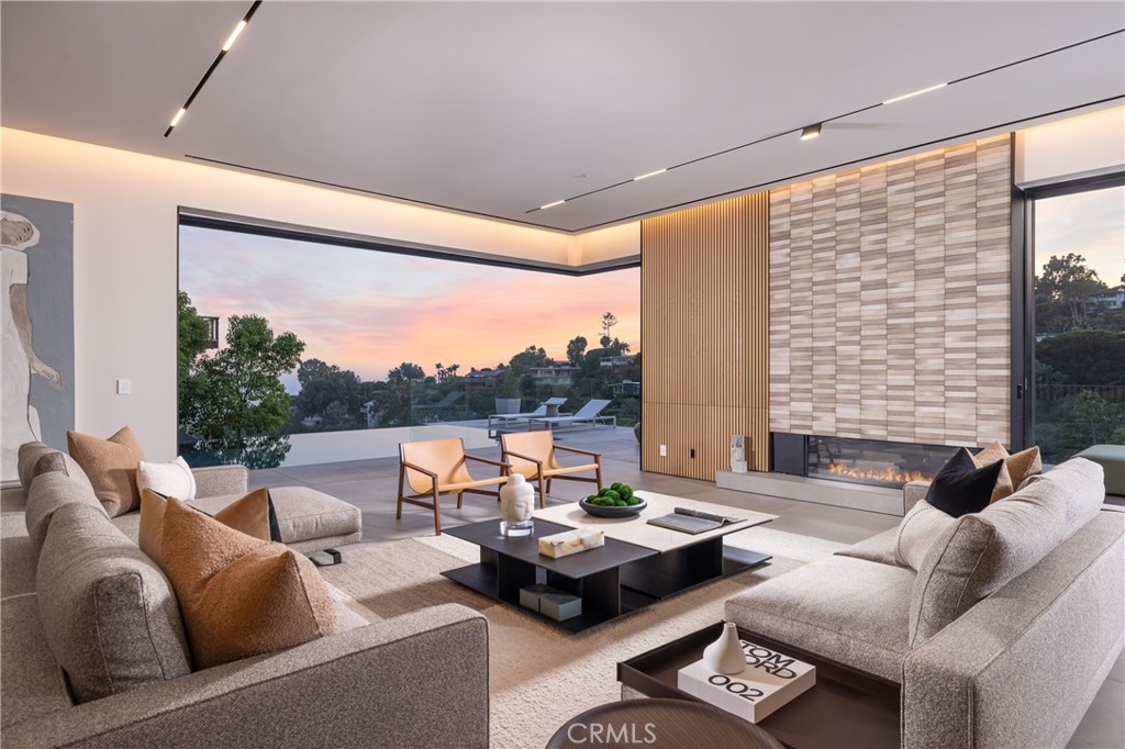 A true architectural marvel, 1000 Oriole is an iconic property that pushes the boundaries of modern architecture and design while capturing the essence of a modern-day residential masterpiece. The stunning architectural jewel has been designed by the esteemed and award-winning architectural firm Tag Front Architects. This newly built contemporary retreat offers breathtaking views of the Pacific Ocean, canyon landscapes, and twinkling city lights by night. It showcases a masterful blend of top-tier materials such as concrete, glass, metal, and various uses of wood. Beyond the private gated entrance, residents and guests will experience natural modern elements with coastal elegance, complemented by ultra-sleek design styling typically found in Hollywood Hills and LA modern architecture. Spanning approximately 6,300 square feet on an oversized 1.4-acre lot, the ocean-view residence offers four well-appointed bedroom suites, four-and-a-half lavish baths, a media lounge, and a bonus media room on the lower level. The interiors are flooded with natural light, thanks to floor-to-ceiling windows and sliding glass pocket doors that open up to ocean-view decks, weaving the indoor and outdoor spaces into one. A set of floating architectural staircases and a private elevator ensure effortless movement through the home's three levels. The main level is an entertainer's dream oasis, highlighted by the open-concept Molteni&C | Dada kitchen and chic dining area, accentuated by the dual sitting room configuration and sophisticated media lounge clad with slatted wood wall coverings, a temperature-controlled glass-enclosed wine wall, and a beautiful Japanese tiled fireplace wall. Outside, the ocean-view deck hosts a saltwater infinity-edge pool and spa, giving the home a setting rivaling the best 5-star resorts. The lower level provides access to two spacious bedroom suites and a versatile bonus media/game room and art studio, with potential to add a home gym boasting incredible views above the pool. Impeccable master craftsmanship is evident throughout the home, with premium materials such as large-slab tile and rift-cut white oak wide-plank flooring, as well as smart-home technology integrated seamlessly. Just moments away from Laguna's iconic beaches, art galleries, and best dining locations, this bespoke residence is the perfect environment to live one's best life and revel in the ultimate coastal lifestyle.