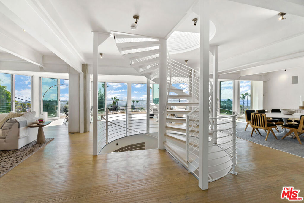 A stunning architectural masterpiece where privacy and creativity converge in the exclusive gated enclave of Cavalleri. Fully renovated with impeccable designer finishes, this home features floor-to-ceiling glass walls, White Oak floors, and a central spiral staircase. Enjoy panoramic ocean and mountain views from multiple decks, including a newly redone rooftop deck offering 360-degree vistas, an indoor wet bar, a built-in BBQ, and a fire pit. The entry level is an entertainer's dream with an open-concept layout, featuring multiple seating areas, serene coastal views, and stacking glass doors that lead onto a wrap-around deck. The dining area flows seamlessly into the chef's kitchen, boasting Miele appliances, Labradorite stone countertops, a gas range with dual ovens, and a large island with breakfast bar seating. The luxurious primary suite overlooks the sparkling Pacific and includes a comfortable sitting area, motorized drop-down television, spa-like bath with dual rain steam shower, free-standing porcelain soaking tub, and direct access to a sun-soaked patio. Two additional en-suite bedrooms and a detached guest suite provide ample space for family and guests. Outside, a grassy lawn wraps around the home, and there are plans available for a future pool. Additional features include a full-home Sonos system, remote-controlled blackout shades, a laundry room, and a 2-car garage. All set within a private, gated community on a quiet cul-de-sac with convenient trail access and a central location near local markets, schools, restaurants, pristine beaches, and more. Experience Malibu at its finest, where breathtaking beauty and refined coastal elegance come together in one remarkable home.
