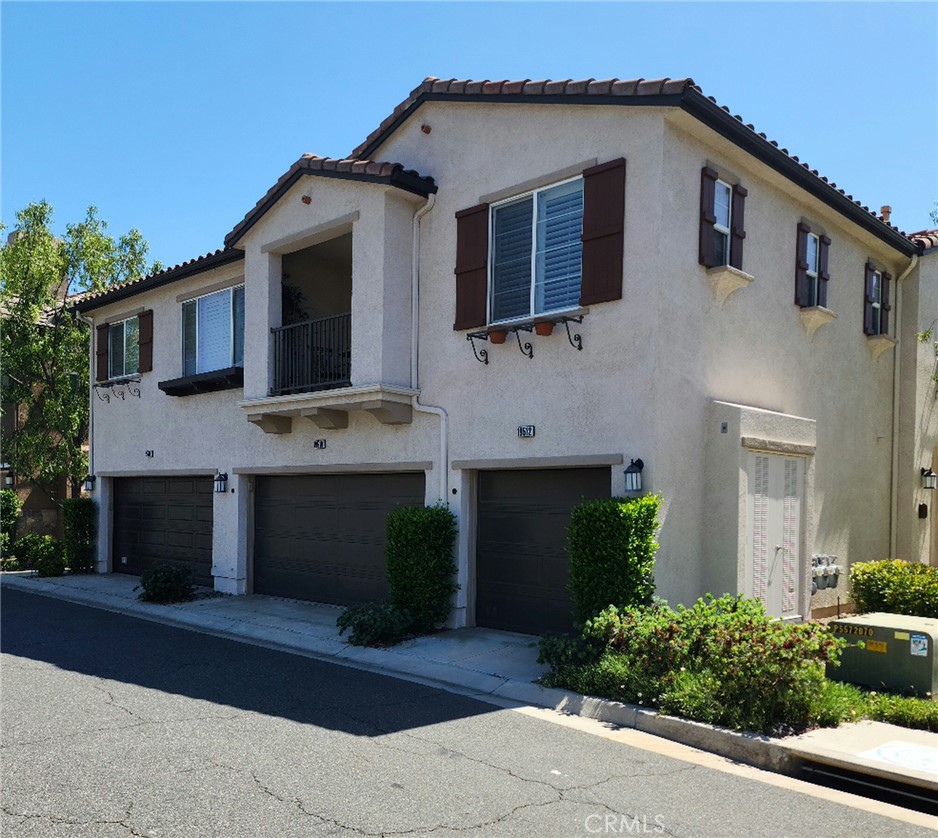 Welcome to this beautifully maintained townhouse in the desirable Mariposa community of Plum Canyon, Santa Clarita. Step inside to an open and airy main living space with plenty of natural light, a cozy fireplace, and direct access to a private balcony—perfect for morning coffee or relaxing evenings.
The kitchen features granite counter tops and stainless-steel appliances. It flows seamlessly into the dining and living areas, creating a comfortable space for both daily living and entertaining. You’ll find two spacious bedrooms, including a primary suite with a walk-in closet customized by Closet World. It also features an en-suite bath with dual sinks and tile floors. The second bedroom is ideal for guests, a home office, or both, with dual sinks.
Additional highlights include in-unit laundry, recessed lighting, under-stair storage, plantation shutters, and manufactured hardwood floors throughout. The one-car garage offers direct unit access and overhead storage, plus there’s an additional assigned parking space. Community amenities include a pool, spa, playground, and clubhouse…all with low HOA fees and no Mello-Roos. Conveniently located near shopping, dining, entertainment, and top schools, this home offers comfort, style, and value in one great location.