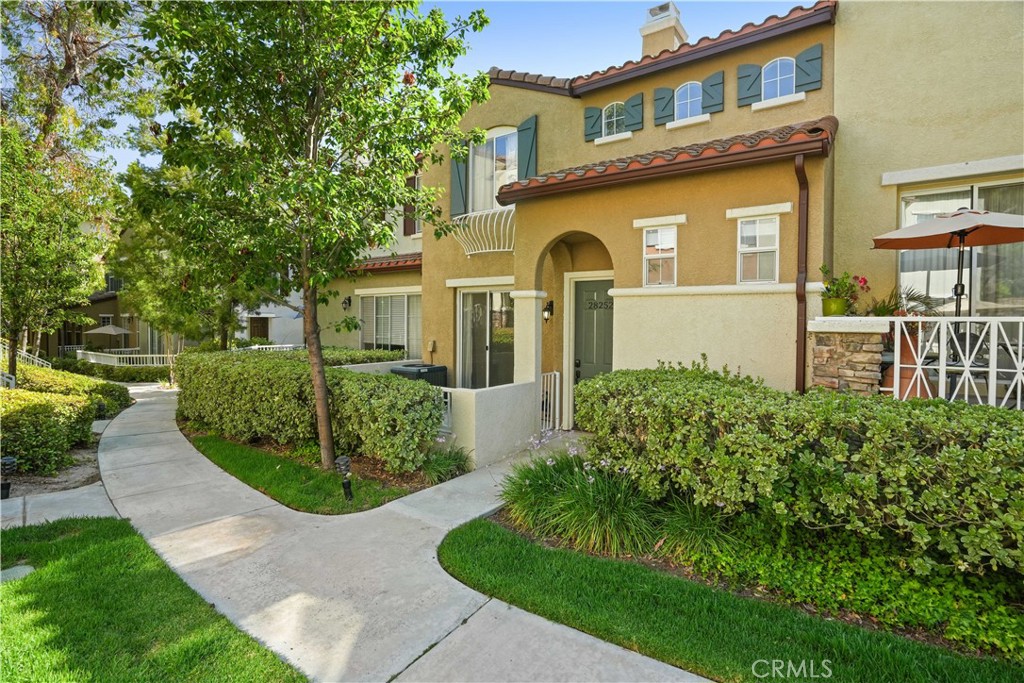 Welcome to this beautiful two-story townhome located in the desirable Valencia Village Walk community. Set in a well-maintained HOA with mature trees, lush landscaping, and wide streets, this home offers both charm and convenience. Step inside to a spacious open-concept layout where the living room, dining area, kitchen, and breakfast nook flow seamlessly together—perfect for everyday living and entertaining. The space features natural wood laminate flooring, granite kitchen countertops, a tiled backsplash, and a built-in bench in the nook with modern touches. For added convenience, the laundry area is located in the hallway leading to one of the two attached garages—yes, the home includes two attached separate one car garages! Upstairs, you'll find a versatile loft space that can be used as a family room or office, along with two generously sized bedrooms, both with walk-in closets. The primary suite features dual sinks, a soaking tub, and a separate shower.
With high ceilings, a smart floor plan, no Mello-Roos, laminate wood look floors, front porch, and access to excellent schools, this property is a fantastic opportunity.