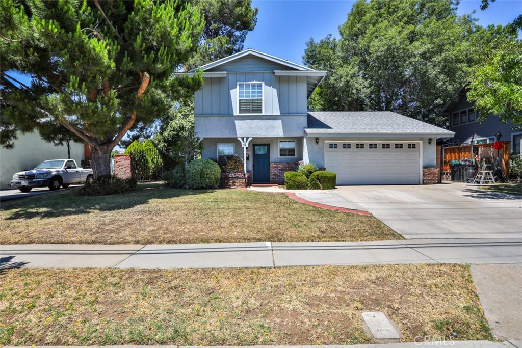 Beautiful two-story home offers stylish upgrades and inviting living spaces throughout! The main level features wood laminate floors, wide baseboards, crown molding, paneled doors, and stunning plantation shutters. The remodeled galley kitchen boasts rich wood cabinetry, soft-close drawers & doors, stainless steel appliances, and is open to the dining and family room. French doors lead to a spacious, fully fenced pool-sized backyard with a covered brick patio, mature trees, and potential RV parking on both sides. A charming arched entry connects the family room to the living room, highlighted by a cozy wood-surround brick fireplace. The powder room completes the downstairs and features a stylish wood vanity, framed mirror, and modern lighting. Upstairs, you’ll find three comfortable bedrooms and a full bathroom. The primary bedroom includes plantation shutters, and mirrored closet doors. The remodeled bathroom offers a bath/shower with tile surround and glass sliding doors, a single wood vanity, and a beveled round mirror. Additional features include dual-pane windows throughout, central air and heating, and direct access to the two-car garage with a laundry area, a loft with storage space, a 50-gallon water heater, and roll-up steel garage doors. Ideally located just a short walk to Marchant Park, offering playgrounds, picnic areas, tennis courts, a basketball court, and baseball fields. Conveniently close to Ekstrand Elementary School, city hall, recreation facilities, and shopping!