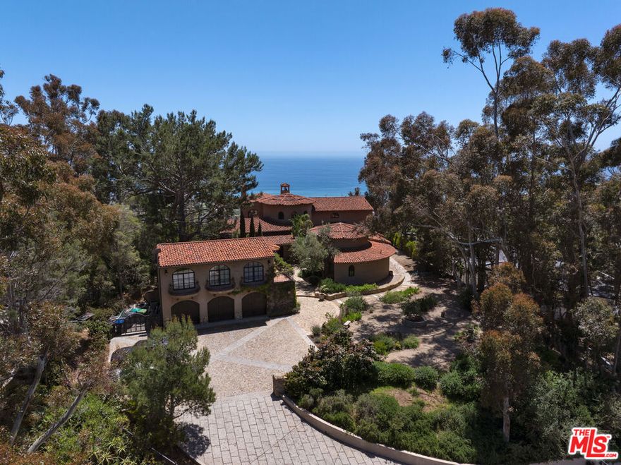 With sensational views, European styling, and amenities galore, this Italian-style villa combines classical design with up-to-the-minute features for year-round comfort and elegant entertaining. Situated behind gates on over an acre of gorgeous Mediterranean landscaping, the property's highlights include a well-appointed guest house, theater, 3000-bottle wine cellar, infinity-edge pool, bocce court, and stunning straight-on views of Catalina and the ocean, plus the sparkling lights of the Queen's Necklace.The carved, double front doors reveal a charming foyer that opens into a majestic entry hall with clerestory windows, a soaring, hand-painted domed ceiling, beautiful limestone flooring, and a stairway with a wrought-iron rail curving up to the second floor. Ahead is the step-down living room, awash in natural light. The room has extraordinary acoustics, ideal for music, with exposed beams, tall, arched windows with views from Palos Verdes to Point Dume, a massive stone fireplace, and double French doors opening to the entertainer's ocean-view patio.The chef's kitchen blends traditional styling with modern efficiency: beamed ceiling, herringbone-pattern reclaimed-tile floors, an island with bar seating topped with exquisite Brazilian Bahia stone, marble countertops, top-quality appliances, a hand-painted fresco, a built-in barbecue, and altar-wood trim from achurch in El Salvador. There is a spacious butler's pantry with additional prep space, storage, and appliances, plus the laundry room adjoins the kitchen and has a door to the side yard.The kitchen opens out to include a large dining area with arched French doors to the ocean-view patio and a formal dining room occupies a round tower with chandelier ceiling, stained-glass window, and curved walls with windows overlooking the pool and ocean views. Off the living room is a theater/family room with a retractable screen, blackout shades, and ocean views.A hall off the foyer leads to a classic bookcase-linedoffice/library with beamed ceilings, limestone floors, a large fireplace, and French doors to the front yard. Continuing along this hallway, the wine cellar / tasting room feels like it could have been imported from a European castle. An en-suite bedroom has a sitting area andocean views. Next door is a gym, also en-suite, with wood floors and a walk-in closet. At the end of the hallway is a circular family room, complete with beamed ceilings, wood floors, courtyard and mountain views, and a bathroom.The estate's upper floor is home to the gorgeous primary suite, with tall, beamed ceilings, antique reclaimed hardwood floors, a huge stone fireplace with fossilized shells quarried in San Luis Obispo, a sitting area, a walk-in closet, and French doors to a private deck with panoramic views. The primary bath has a lounge, a fireside, ocean-view, jetted, Carrara-marble tub, dual water closets, and a door to a partially covered private deck. Beyond the bath is a bonus work/play/studio room with ocean views and a nook with a hand-painted mural.At the front of the house there is a patio and fountain with sweeping mountain views. A generous motor court offers parking for nine cars. Above the three-car garage is a charming, private guest house, with a large living/sleeping room with beamed ceiling, herringbone tile floors, mountain-view balconies, a separate dining room, a kitchen, and a bath.The back of the property is terraced, with a selection of open and covered seating, beautiful pool and spa, lawn, dining areas, fire feature, bocce court, outdoor shower, olive trees, and views, views, views. The home's additional features include multi-zone air conditioning, full-house sound, plus security and alarm systems. Built by one of Malibu's most respected builders, this exceptionally private estate is located just minutes from central Malibu, beaches, trails, dining, and all that Malibu has to offer.