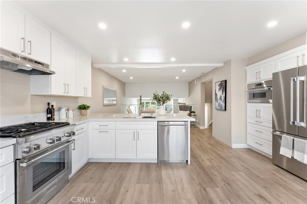 Stunning, completely remodeled almost 1,900 SF Villa Valencia townhome with attached 2-car garage with direct access! Located in the heart of Warner Center adjacent to dining/shopping at the Westfield Mall & Village, shops and eateries off Topanga Canyon, and minutes to the beach with easy freeway access. Boasting the largest floor plan in the complex, this thoughtfully renovated townhome greets you with a private gated courtyard with Spanish Saltillo and patterned tile flooring. Step inside where you’ll find a formal entry with coat closet with new wide plank luxury vinyl flooring found throughout. The entry opens to the spacious sunlit living room featuring fireplace and large glass sliding door that leads out to the front patio. The remarkable chef’s designer kitchen has been completely remodeled boasting real quartzite stone countertops, soft close cabinetry, breakfast bar seating, and a Thermador stainless appliance suite including built-in range with oven/stove, fridge, microwave, and dishwasher. The kitchen opens to the separate formal dining room with sleek modern glass railing which overlooks the living room. This level also has a convenient guest powder bathroom and separate laundry room with storage cabinets. Upstairs you will find two oversized bedroom suites. The primary bedroom has a double door entry, large wraparound closet with built-ins plus additional walk-in closet, and private en-suite upgraded bathroom with dual sinks, walk-in shower, and separate bathtub. The second bedroom suite could also serve as den/bonus room featuring double door entry, high vaulted ceiling, wet bar with sink, Juliet balcony overlooking the complex, large walk-in closet, and access to its own upgraded bathroom with walk-in shower. The two-car garage has built-in storage and has direct access to the townhome. The complex amenities include swimming pool, spa, and picnic area, and nicely landscaped grounds. Don’t miss this rare offering!