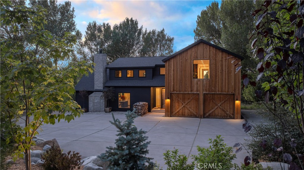 Welcome to 43612 Shasta Road, the crown jewel of Big Bear Lake’s highly coveted Moonridge neighborhood. This modern mountain home sits on over one half acre and has been completely and thoughtfully reimagined by one of L.A.’s top designers as a personal private retreat. Design of this caliber is a triumph and rarely offered for sale. The beautiful blend of rustic barnwood and sleek contemporary materials make this home Pinterest worthy. The custom steel entry door sets the tone for the elevated design and meticulous attention to detail that awaits within. Luxury finishes are found throughout the home, including white oak floors, hand-plastered walls, and one-of-a-kind lighting. Step into the open living room, dining room, and chef's kitchen with 18 ft beamed ceilings and large masonry wood-burning fireplace. Walls of glass and 10 ft doors seamlessly connect the indoor entertaining area to the aged Ashwood wraparound decks. The well-equipped kitchen features a massive island with a gas range and breakfast bar, as well as two sinks, an antique butcher block, natural stone countertops, and paneled appliances. This home features dual primary suites, one on the entry-level and one upstairs, both featuring en-suite bathrooms and extensive mountain views through large picture windows. An expansive third bedroom, currently used as a bunk room, offers plentiful options for children and guests and has a private en-suite bathroom. An upstairs family room is the ideal space for a home theater or relaxing after a day in the mountains. Located moments from Bear Mountain and stunning national forest trails, this home offers a peaceful setting with endless views, exceptional quality, and excellent proximity to Big Bear’s best amenities. Just a few hours from Los Angeles and Orange County, while feeling worlds away, this private retreat is one of a kind.