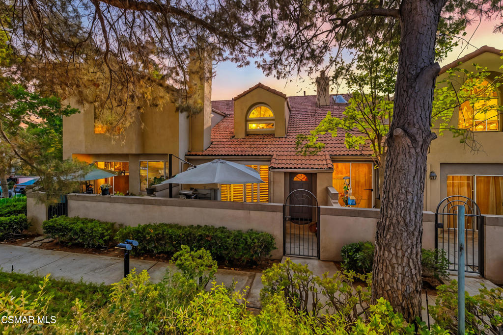 Gorgeous Spanish-Style Townhome in Scenic West Chatsworth! Perched in a serene, Spanish-inspired community near the iconic ''Garden of the Gods'' and Stoney Point rock formations, this beautifully updated home offers the best of California living--on the cusp of Ventura and Los Angeles Counties.Step through a peaceful front patio with a stunning outdoor stone fireplace, and into a warm, light-filled family room with soaring vaulted ceilings, cozy fireplace, and a newer dual-pane slider with plantation shutters. Wood-like floors flow seamlessly throughout, creating a clean, modern feel. The upgraded kitchen features a full suite of high-end KitchenAid stainless steel appliances, open sightlines to the family room, and an adjoining dining area with dramatic ceilings--perfect for both everyday comfort and entertaining. Retreat upstairs to the spacious primary suite with a private balcony, expanded walk-in closet, and luxe en suite bath. Spacious secondary bedroom offers access to the upper private balcony. Large loft offers ample opportunity to be transformed to fit your lifestyle. Bathrooms are enhanced with newer vanities, modern fixtures, and abundant natural light from a skylight. Additional upgrades include recessed lighting, fresh neutral paint, upgraded baseboards, newer dual-pane windows and sliders, newer HVAC, and water heater. Sleek newer refrigerator, washer, and dryer are all included. 2 attached car garage with upgraded cabinets and flooring! Perfect to showcase your cars. Enjoy resort-style community amenities including lush greenbelts, a sparkling pool, and a relaxing spa. Conveniently close to the 118 Freeway, shopping, dining, hiking trails, and surrounded by breathtaking mountains--this is California living at its finest.