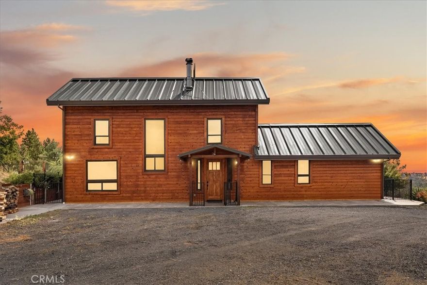 Looking for space, privacy, and rustic elegance? This custom 3-bedroom, 2-bathroom home offers 4.85 acres of peaceful living with sweeping canyon views, multiple outbuildings, and an oversized garage with an ADU above. Built with steel columns and designed for both comfort and durability, this home is truly one of a kind.



Step inside and you’ll be welcomed by tons of natural light, huge vaulted ceilings, rustic wood finishes, and engineered hickory floors. The chef’s kitchen features a peninsula island with breakfast counter, high-end Café stainless steel appliances, a gas cooktop, French door wall oven, and a convection microwave. Soft-close cabinetry, a farmhouse view over the sink, and custom touches throughout make this kitchen a true highlight.



The spacious primary suite on the main floor offers French doors to the patio, a walk-in closet, and an incredible view. The spa-like bath includes a custom oversized concrete soaking tub set beneath a bay window, a live-edge vanity, and a walk-in shower for a true luxury retreat. Upstairs, two generously sized bedrooms share access to the upper deck and a full guest bath.



Built with fire safety in mind, the home includes fire-treated siding, steel roof, slab foundation, full fire suppression system, sealed envelope construction, owned solar, and a Generac whole-home generator with a 5,000-gallon water storage tank.



Outdoors, enjoy raised garden beds, a fully automated greenhouse, mature fruit trees, multiple chicken coops, garden shed, stamped concrete patios, and a gated entry with keypad. The 24’ x 36’ garage includes an ADU with stair chair lift, perfect for extended family or rental income. Additional shop space, multiple outbuildings, and endless privacy make this property ideal for both homesteading and retreat living.



Located just 2 miles from Lake Oroville, 5 miles from the Feather River, and 1.5 miles to Hwy 70 with no road noise, this home blends convenience, security, and serenity. Hurry before this incredible home is gone!