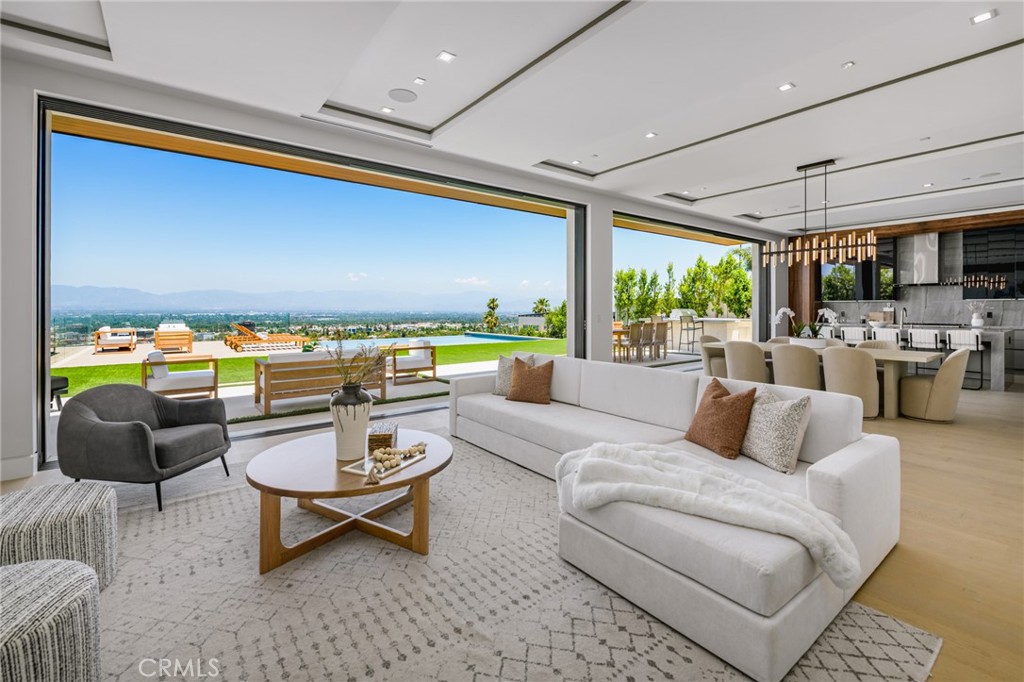 A one-of-a-kind architectural masterpiece where striking design meets endless views. Perched on a quiet, wide street, this brand-new 2025 estate showcases unobstructed panoramas of city lights, rolling hills, and golden sunsets—arguably the most breathtaking vantage point in Tarzana. Every inch of this contemporary showpiece has been meticulously crafted to frame and celebrate the views. Walls of glass and disappearing pocket doors erase the boundary between indoors and out, opening to a private outdoor paradise with an infinity-edge plunge pool spilling into the skyline. Inside, soaring 11-foot ceilings, wide-plank oak floors, and an open layout create a grand yet effortless flow. The sunlit great room combines living, dining, and a chef’s kitchen with custom cabinetry, an oversized island, and top-of-the-line Thermador appliances. The primary suite is a private retreat, elevated with mesmerizing views, dual showers, a sculptural soaking tub, and balcony escapes. Beyond its five bedrooms and six baths, this home elevates lifestyle with a three-level theater, gym, sauna, home office, and a bar & billiards lounge designed for unforgettable entertaining. This is more than a home—it’s an experience. Step inside and look out. You’ve never seen anything like it.