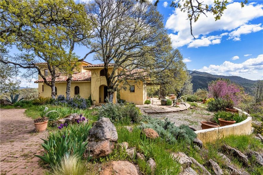 Incredible Tuscan Villa atop Mount Dali-Dona has panoramic views of Clear Lake, Big Valley & Mount Konocti. You will feel like the rest of the world disappears the moment you enter this property. As you make your way up the wildflower-lined driveway, the manzanita and mature oaks will welcome you to this incredible home. The residence is built with imported antique beams, French country-style kitchen with fireplace, quartzite counters, unique old-world aesthetics, heated floors, dual solar/PG&E power, and a wood stove. The property features 3 levels, 3 bedrooms and 3 bathrooms, wine cellar, large basement, formal living room, office, walk-in pantry. And a large fenced garden with irrigated garden beds and a planting shed. A separate building with ADU potential offers storage, 1 half bath, a loft and a sink, adjacent to the vineyard with separate electric meter and septic. 1.6 acres of Rhone grapes and olive grove. Also included is the sale, de-stemmer/crusher, filter press & barrels to produce your own wine! This expansive yet cozy home is full of charm and has unparalleled views from every angle. The estate is situated on 27+/- acres and has gated access. Close to downtown Kelseyville, restaurants and shops.  Borders the Clear Lake State Park with great hikes, lake access and camping. Secluded and peaceful, this property offers an incredible opportunity to observe wildlife and disconnect from the day-to-day hassle.  Potential for ADU or rental property.