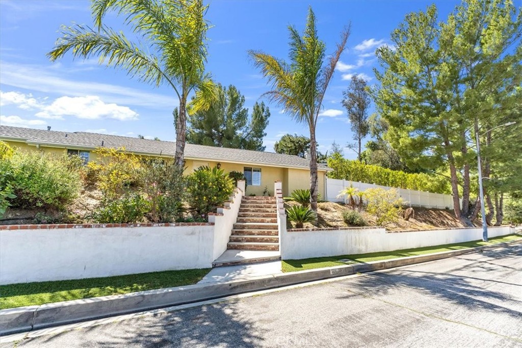 This charming 3-bedroom, 2-bathroom home is located in the sought-after Sunland Estates neighborhood and sits on a spacious corner lot. Inside, you'll find newly upgraded wood floors throughout and freshly painted bathrooms. The kitchen boasts granite countertops and stainless steel appliances. Wood shutters are featured throughout the home, including the master bathroom, which leads to a large walk-in closet with plenty of shelving. The master bedroom is spacious, offering mountain views, while the other two bedrooms are also generously sized with large mirrored closets. The attached garage includes drawers, shelving, and washer/dryer hookups. Outside, the front yard features a garden-like space with an enchanting water fountain and stunning mountain views. The living room has a cozy wood-burning fireplace for chilly evenings and a sliding glass door with wood shutters that opens to a large covered patio, perfect for entertaining. The backyard offers a free-standing shed for extra storage, a high fence for added privacy, and ample space for outdoor activities. This home is a must-see!