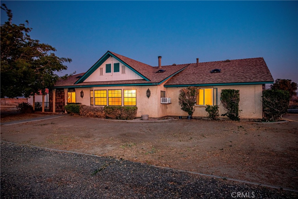 Enjoy ranch-style living with two homes PAID SOLAR and is situated on a sprawling 2.2 acres, making it a perfect place for guests, in-law quarters, and multi-family living! Beginning with a secured perimeter of block masonry and wrought iron fencing, dual entrances to the property with a
circular driveway, an electric gate, and finishing with the east and west perimeter of wood fencing and chain link in the back. The main home offers 1,814 sq. ft. of living space with 2 bedrooms + a bonus room with no closet and 2 bathrooms. Upgrades include a newer roof and ceiling fans throughout. A covered patio greets your guests upon entry. The spacious living room features a neutral-colored carpet, a wood-burning stove on a brick hearth with a stone backsplash, and a window evaporative cooler. The dining room has its own character with oak wood wainscoting, tile flooring, and French doors leading to the backyard. The kitchen boasts custom oak cabinetry with plenty of storage, tile countertops, a garden window, a large pantry cabinet with custom pull-out shelving and organizers, and appliances that include a freestanding microwave. Primary bedroom has neutral color carpet and dual closets with custom Oak cabinets. The primary bathroom has a dual vanity, a large walk-in shower, and an oversized jacuzzi tub wrapped in custom oak, giving you an indoor spa feeling. Secondary bedroom and bonus room are located on the west side of the home, with one bedroom having a dedicated closet space. The guest bathroom has a stand-alone shower and a single sink vanity. The laundry room is indoor and has a storage closet. The guest house/ADU which is 1,100 sq. ft. has 1 bedroom plus a bonus room and 1 bathroom. Upgrades include a newer roof, wood laminate flooring, dual evaporative cooling systems and ceiling fans throughout. Open floor plan with a spacious dining room and living room that offers custom crown moulding and a wood-burning stove on a beautiful custom-built brick hearth. The kitchen offers custom Oak wood cabinets, stainless steel appliances and a door leading to the backyard. The bedroom has neutral color carpet, beautiful woodwork of custom cabinets and storage as well as a nice-sized closet. The bathroom has a stand-alone shower and a single sink. Indoor laundry area. The home continues with an enclosed patio with tile flooring, dual ceiling fans, and plenty of natural lighting, perfect for a hobby room or sitting room.