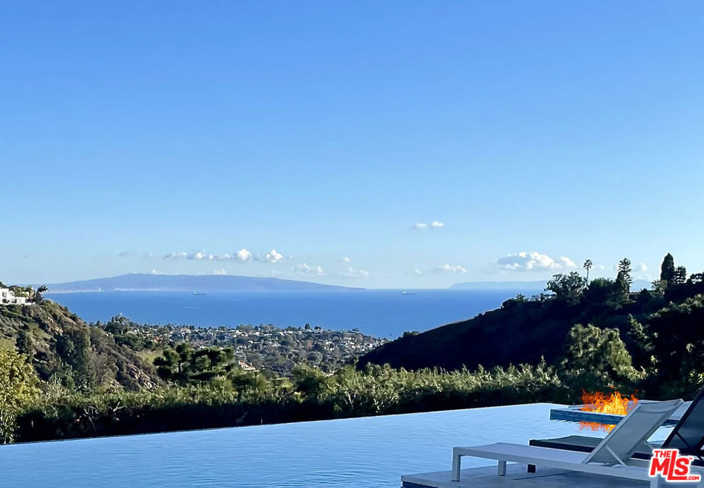 Stunning Queen's Necklace ocean views from this spacious 2-story Hampton-style estate, on a nearly 0.61 Acre corner lot, presenting 6 beds, 6 baths, an infinity pool, plus a large separate grassy area and 3 car garage situated on approx 8,200 SqFt. Just a few minutes from the beach and famed Palisades Village with world-class dining/shopping, and hiking trails, making this prestigious location so desirable and convenient. Entertaining is effortless with an adjacent butler's pantry and luxurious formal dining room, large family room, soaring high ceilings, and formal entry. Gourmet kitchen with breakfast area, eat-in counter Bar, and top-of-the-line appliances. French doors throughout lead to the sparkling infinity pool with spa and inspiring views, a maid's room, and a bonus room that could be a gym, playroom, or guest room. The grand Primary Suite upstairs features an impressive stone bathroom and whirlpool Spa tub, with a fireplace, sitting area, roomy walk-in closet, and balcony. A once-in-a-lifetime opportunity to own and enjoy the most exquisite estate residence, in a Private, Gated community with only 6 homes. Best value in prime Pacific Palisades location! Submit all reasonable offers!