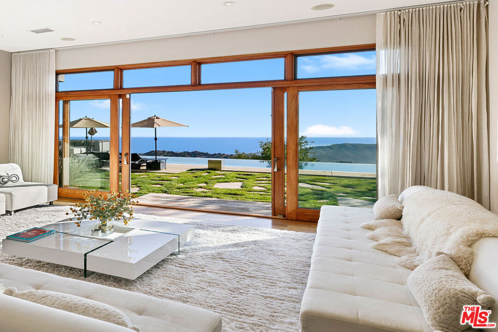 Jaw-dropping ocean views from this architectural masterpiece with infinity pool overlooking Point Dume set on nearly 6 lush acres. Decadent primary suite with panoramic ocean views, fireplace, huge closet, and spa bath featuring soaking tub and steam shower. Entertain in style with a projection home theater, chef's kitchen equipped with Viking appliances, and a grand living room with soaring ceilings and wall-to-wall ocean views. A detached guest house with a private entrance offers the perfect space for a home office, studio, or additional accommodations. Enjoy endless hikes with trails on your own property, and sit by the pool as you take in the most dramatic sunsets in the world. With a 3-car garage and generous guest parking, this exceptional property delivers privacy, elegance, security and Malibu living at its finest.