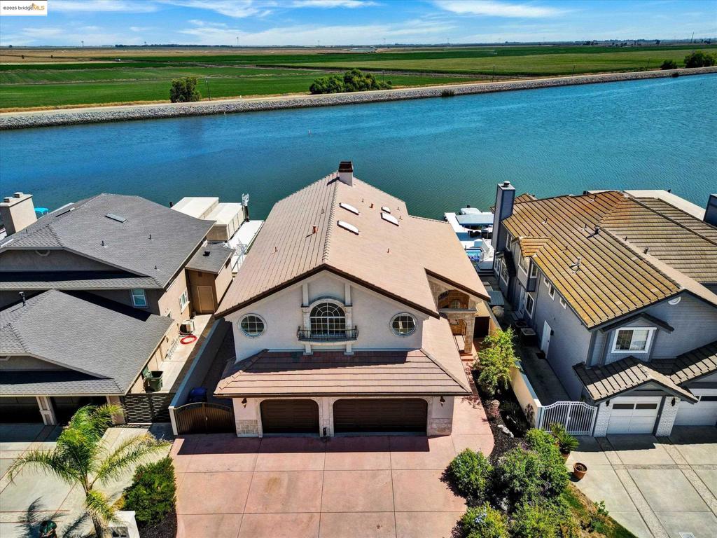 Delta Access Custom built home with rare and highly sought after South Eastern exposure and minutes to fast water, marina and gas! This home was built by a well known local builder for himself - and it shows in the design, function and quality. Double u dock with hydro-hoist and one covered port. Large deck. This 3774 sq ft gracious home is newly updated and beautifully rehabbed, featuring an extra large upstairs bonus space with a full bathroom. Upstairs laundry room. RV Parking! Stucco exterior has been freshly painted as well as the entire interior. Kitchen, newly updated, features granite counters. LV with fireplace and a wet bar the overlooking the water, perfect for entertaining; primary bedroom features its own fireplace and spacious bathroom and 2 closets. (Bathtub even has a water view!). Bright and clean 3 car garage with epoxy flooring. The large downstairs bedroom with full bath access and private entrance has possible in-law set up.