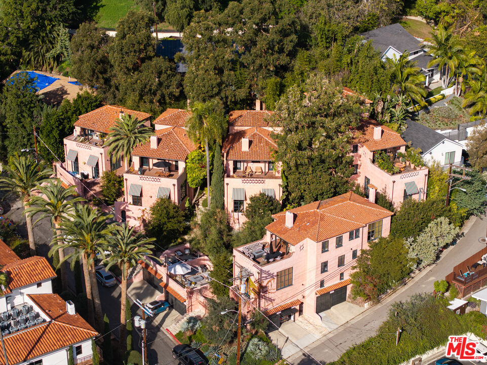 *** 3rd price reduction - $650,000 from originally listed price *** Welcome to Las Orquideas, a historic Andalusian garden village built in 1929 by Wilfred Buckland, and immaculately restored by Howell & Padgett in 2019, whose previous works include the iconic Torre del Moro condos in Beachwood Canyon. Las Orquideas perfectly retains that signature glamour of Hollywood's Golden Age while offering modern and luxurious amenities of a new construction property. Perched in the foothills of the Hollywood Hills, this compound has five villa-like structures consisting of nine units and a flex space. This whimsical complex was designed in the early days of Hollywood's Golden Era by Wilfred Buckland, Cecil B. DeMille's frequent art director. Buckland, the original owner, developed the property as a replica of a Spanish hill town with ascending walkways, connecting gardens, and intimate plazas. An abundance of lush mature landscaping lines the stone walkways. Each villa-like structure is covered in coral-colored stucco and features original architectural period details such as interior arches, beamed ceilings, fireplaces, wood floors, and stained glass. Lofty ceiling heights and oversized windows bring in much natural light. A remodel of each unit was completed several years ago with strict attention to retaining each unit's strict authentic integrity and character. Modern updates include custom cabinetry, stainless steel appliances, and an in-unit washer and dryer. Several units feature private patios or balconies overlooking Hollywood Blvd. and the city. Las Orquideas is a Mills Act property with a financial incentive for historic preservation, offering property tax savings for owners who invest in rehabilitating historic buildings. Las Orquideas is part of the Golden Era Collection, four impeccably restored multifamily complexes in Los Angeles.