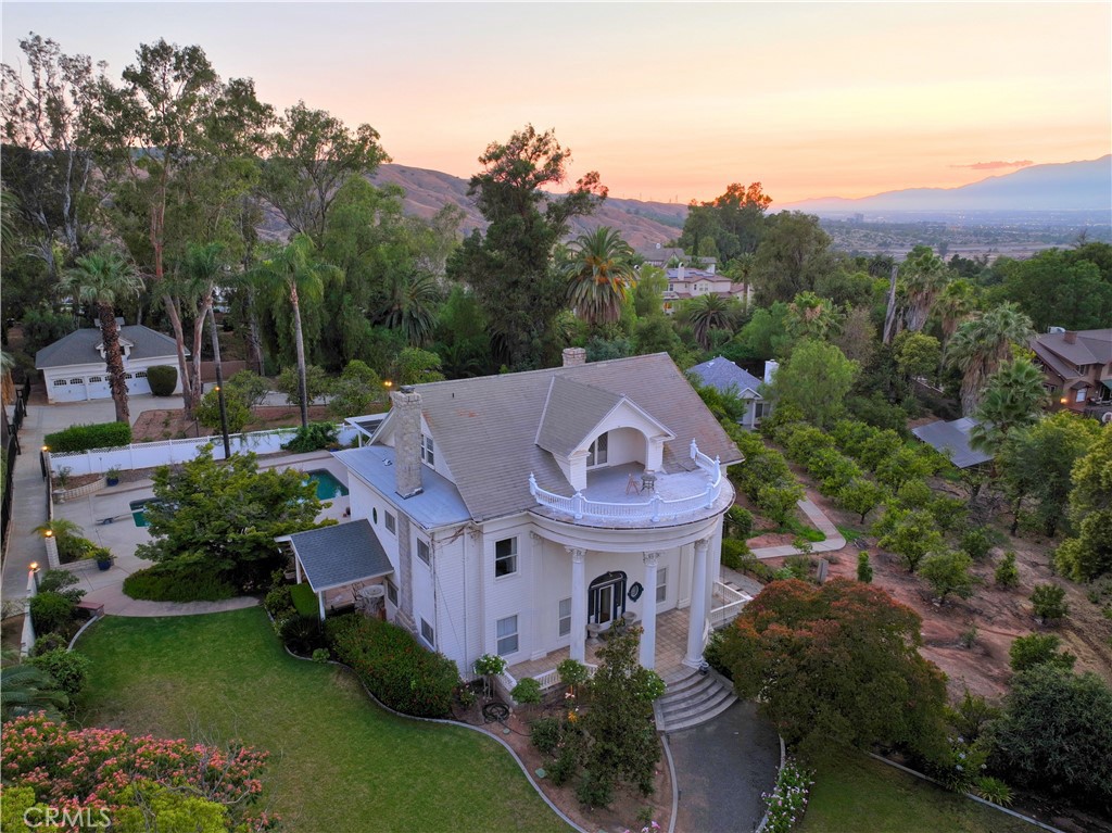 Stunning historical build nestled in the coveted Smiley Heights neighborhood. Set on more than 95,000 square feet of gated grounds, this estate blends classic character with a unicorn lot, and offers a rare mix of privacy, character, functionality, and charm.
The main residence features three bedrooms upstairs, including a primary suite with a huge walk-in closet. A finished third-floor loft offers its own bedroom, bath, and generous walk-in closet. The main floor includes a full laundry room and a thoughtfully designed, upgraded, kitchen. Kitchen offers a built-in refrigerator, instant hot water, and appliances that will remain with the home.
A separate two-bedroom, one-bath guest house with its own kitchen and living room provides flexible living options and adds significant versatility to the property. Outdoors, a sparkling saltwater pool and cabana with owned solar are complemented by an expansive orchard of more than sixty fruit trees, including citrus, apple, guava, jujube, lemon, pomegranate, grapefruit & olive. Raised garden beds provide an ideal space for fresh produce.
The original carriage house has been transformed into a three-car garage, fully finished with power and drywall, plus 750-square-foot loft upstairs that is perfect for a studio, office, or creative workspace. Electronic gates, block and wrought iron fencing, and an alarm system provide security and peace of mind. Energy efficiency is supported by a leased solar system, which services both the main and guest homes and transfers at $228 per month.
Born in the citrus boom era, this home is a Neoclassical estate, with its sweeping front columns and symmetrical design inspired by Greek and Roman architecture — a true statement of elegance and history in Redlands. With its resort-style amenities, flexible living spaces, and expansive grounds filled with history and natural beauty, this property offers a lifestyle rarely available in Southern California.
Beyond the property’s gates, residents enjoy easy access to the very best of Redlands. Within fifteen minutes, you can stroll through historic downtown with its charming shops, coffee houses, and fine dining. Catch a concert at the Redlands Bowl, or explore the trails and scenic vistas of Prospect Park and the San Timoteo Nature Sanctuary. Conveniences such as grocery stores, farmers markets, and parks are nearby, all against the stunning backdrop of the San Bernardino Mountains.