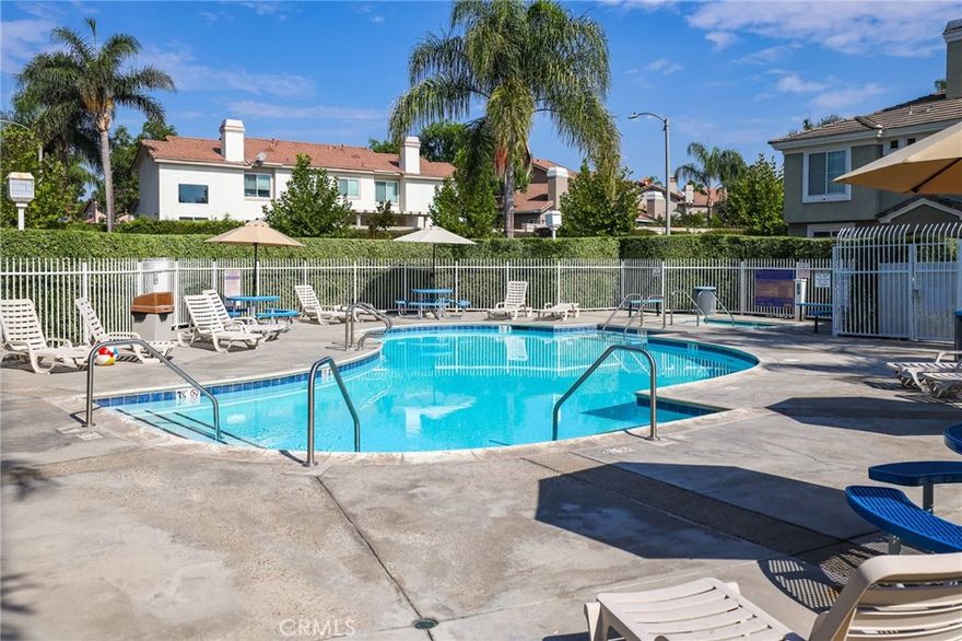 Welcome to this beautifully upgraded home in the highly desirable Laing’s First Edition community in Corona Hills. This spacious residence offers 3 bedrooms, 2.5 bathrooms, and an open-concept layout designed for modern living. Natural light pours into the living area through a skylight, creating a warm and inviting ambiance. The updated kitchen is a showstopper, featuring quartz countertops, custom cabinetry, a designer mosaic backsplash, and stainless steel appliances. A cozy breakfast bar flows seamlessly into the dining and living spaces, where you’ll find a charming fireplace, hardwood/tile flooring, crown molding, and ceiling fans that add comfort and style throughout. Enjoy indoor-outdoor living with shuttered sliding doors that open to a private front patio, plus a balcony off one of the bedrooms. The luxurious primary suite is your personal retreat, complete with a large walk-in closet and private en-suite bath. This sought-after community offers residents access to a sparkling pool and lush gardens, while a 2-car attached garage provides convenience and storage. Perfectly located, you’re just a short stroll to shopping, dining, movie theaters, parks, and hiking trails—with easy access to the 91 and 15 freeways. Low HOA and low taxes make this home an even greater value!