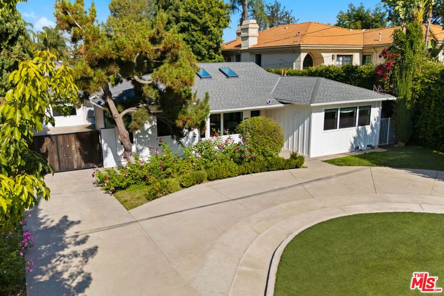 Experience the best of California living in this stunning modern farmhouse, perfectly positioned on a flat 9,700+ sq. ft. lot South of Ventura Boulevard. This single-story home masterfully blends modern luxury with warmth and functionality. A circular driveway welcomes you home, while a gated side drive leads to a beautifully finished detached garage - ideal for use as a studio, gym, or office. Inside, natural light pours into an open-concept floor plan featuring vaulted ceilings, skylights, and designer details throughout. The Chef's Kitchen is a true centerpiece with a Bertazzoni range, custom cabinetry, quartz countertops, and a generous island that encourages gathering. The primary suite boasts floor-to-ceiling closets and a newly remodeled en-suite bathroom. Both the primary bedroom and main living space open to a spacious deck with a built-in gas BBQ - perfect for effortless indoor-outdoor entertaining. The backyard feels like your own private resort, complete with a sparkling swimmer's pool with new gas-heating system, a putting green, and new turf lawn for low-maintenance enjoyment. Every element has been designed to create an inviting flow between indoor comfort and outdoor leisure. Just steps from Whole Foods, Regal Cinemas, and acclaimed dining like Mizlala, Little Izakaya by Katsuya, and Los Angeles Times' "Restaurant of the Year," Anajak Thai. An exceptional opportunity in prime Sherman Oaks with ample room for future expansion or customization.