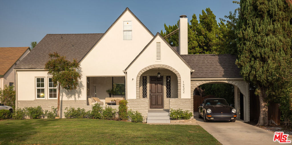 Located on a picturesque tree-lined street in prime Burbank, this 4 bedroom, 3.5 bathroom 1927 Tudor Revival residence offers architectural artistry and refined living. Set upon an expansive, gated lot with a large pool and back studio, this 3,060 sq. ft. home offers space, historic charm, and amenities for ease of living. Past the grassy front lawn, the restored wood front door is flanked by original beveled, leaded glass windows and opens to the home's main living space, with chevron-patterned flooring extending throughout. Soaring vaulted ceilings greet you while natural light floods through the front oversized picture window. The formal living room, crowned by a commanding fireplace, creates an atmosphere of both intimacy and grandeur. The thoughtfully reimagined kitchen serves as the heart of the home, featuring custom oak cabinetry and quartz countertops. A generous center island provides bar seating, while a charming breakfast nook, framed by windows, offers a peaceful corner to enjoy the morning light. An adjacent formal dining room offers a large space for home entertainment. Two generously sized bedrooms are found on the main level, each bathed in abundant natural light with custom sliding barn-style closet doors. The bedrooms share a conveniently located full bathroom with a refined double vanity and bathtub, creating an ideal layout for family living or hosting guests. The second floor reveals a magical children's bedroom tucked beneath a half-pitched ceiling. Adjacent, the primary suite offers a cozy ensuite den/office area, soaring pitched ceilings, and a spacious ensuite bathroom. The opulent backyard includes a large pool, grassy lawn, and a back studio, all surrounded by podocarpus hedging and fencing for privacy. A spectacular swimming pool takes center stage, artfully framed by two pergolas with wooden beams that create natural outdoor rooms. A converted garage sits at the rear of the property and has been artfully transformed into a guest suite or home office, complete with a half bathroom and pool views, an ideal space for work, creativity, or hosting. Ideally located, the property sits within walking distance of Burbank's vibrant dining scene, boutique shopping, parks, and highly-rated schools. The tree-lined streets and neighborhood character provide both privacy and community, while conveniently adjacent to Los Angeles' entertainment industry and cultural attractions. This refined Tudor home represents a rare opportunity to own a piece of Burbank's architectural heritage. The generous lot size, thoughtful improvements, and prime location create exceptional value in one of Burbank's most desirable residential enclaves.