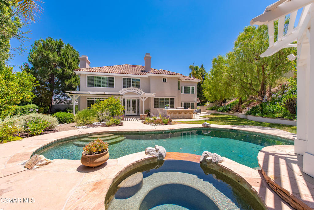 Set atop a knoll in the prestigious Three Springs neighborhood, this beautifully appointed home offers luxury living with a private pool, sweeping views, and a rare 4-car garage. The flexible floor plan features 5 bedrooms and 4.5 bathrooms, including a desirable downstairs ensuite--perfect for guests or multigenerational living. The spacious kitchen opens to an inviting family room with built-in bar and flows into light-filled living and dining areas with soaring ceilings and elegant architectural details. Upstairs, the expansive primary suite feels like a private retreat with a cozy fireplace, sitting area, dual walk-in closets, and a spa-inspired bathroom. Three additional upstairs bedrooms include one ensuite and two sharing a hall bath.Step outside to your private backyard oasis with a pool, grassy play area, and tranquil views--perfect for entertaining or unwinding in comfort.This is a rare opportunity to enjoy space, style, and value in one of Westlake Village's most sought-after communities.