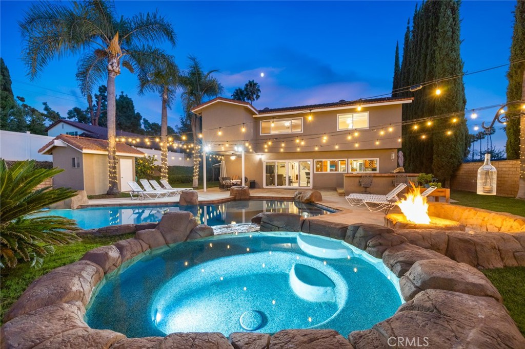 Welcome to 19831 Caprice Dr, a beautifully upgraded 4-bedroom, 4-bathroom home on a quiet cul-de-sac in Yorba Linda. The layout includes a full bedroom and bathroom downstairs, plus a spacious bonus game room with plumbing ready for a bar that can be used as a playroom, theater, or additional bedrooms. The upstairs is also complete with an upstairs master bedroom with a walk-in closet as well as two bedrooms that are perfect for guests or an office. The backyard is a private retreat with a rock pool, jacuzzi, baja shelf, slide, firepit, outdoor kitchen, and poolside bathhouse with shower—perfect for entertaining. Inside, you’ll find a modern kitchen with a double oven and 6-burner range, soft-close cabinetry with pull-outs, and updated flooring throughout. Just off the kitchen is a dining room complete with custom pull-outs perfect for all your large appliances or added storage. Some of the recent upgrades include- Luxury Vinyl Plank and ceramic tile (2023), interior and exterior paint (2023), copper wiring as well as 200 AMP panel (2023), entire HVAC system replaced (2024), newer dual pane vinyl windows, This home is ideally located near Fairmont Elementary and Yorba Linda High School, with convenient access to shopping, dining, and grocery stores. Combining comfort, upgrades, and location, this Yorba Linda gem is move-in ready.