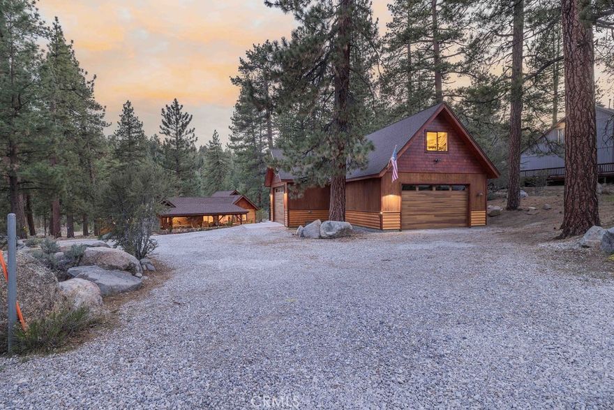 A rare blend of serenity, style, and space awaits on this enchanting 3.5+ acre (fully usable) retreat, where over 580' of Grout Creek flows gently along the rear of the property—bringing the beauty of nature right to your doorstep. Thoughtfully remodeled from top to bottom, this captivating 3-bedroom, 2-bath home offers refined mountain living with modern comforts throughout. Step inside to discover radiant heated floors in the kitchen and bathrooms, an A/C system in the living room and kitchen, and a spacious layout ideal for both quiet mornings and lively gatherings. Outside, expansive tuff flex decking invites you to sip coffee beneath the pines or dine under the stars, surrounded by the soft sounds of the creek. An impressive detached 6 to 8 car garage provides ample storage for toys and tools, while the upstairs bonus room—complete with water hook-ups—offers potential for a studio, guest space, or private office. Below the main house, a bonus rec/game room adds even more space for fun and entertainment. Sustainability and self-sufficiency shine with a fully owned solar system and well water on site—ideal for those craving both luxury and independence. Located near Captain John’s Marina and the west boat ramp, this rare offering combines the best of adventure and escape. Whether you’re seeking a weekend getaway or a full-time haven, this is where your story begins—rooted in nature, wrapped in elegance, and designed to inspire.