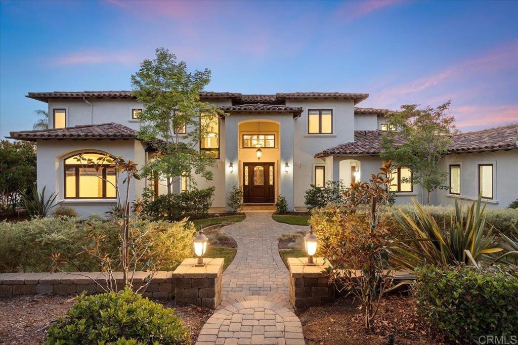 Stunning Spanish estate situated on a FLAT 1.2 acre private lot on the sought-after West side of Olivenhain! This 2011 custom-built estate is the epitome of luxury living, offering panoramic sunset views and westerly breezes and room for the ultimate in entertaining. Multiple fruit trees, raised vegetable garden beds, a chicken coop and an Olympic-size sand volleyball court caters to the active S. California lifestyle. A BBQ island and patio fire pit create an environment for entertaining guests. The lot offers multiple site options to add a pool, ADU or horse facility. The gated property on a private street provides easy access to Encinitas' horse trails and hiking the renowned Spooks Canyon and its winding river trail. The custom home features soaring ceilings throughout that create an ambiance of grandeur and space, with a junior primary suite downstairs and an elegant second level primary suite with access to a Westerly view deck. The heart of the home is the great room featuring a large kitchen island ideal for both meal preparation and casual dining, along with top-of-the-line Wolf double ovens, a gourmet Wolf gas range, and a Sub Zero fridge/freezer. Flowing seamlessly from the kitchen is the inviting family room, complete with a stacked stone fireplace and sweeping views, ideal for relaxed gatherings or intimate moments. From the dining room, French doors open to the back patio for al fresco dining! A optional bedroom/office completes the downstairs. Upstairs you'll find two secondary bedrooms, a huge open loft and a flex room perfect for any family's needs. Convenience meets luxury with whole house water filtration, a mudroom, laundry room and even a dog wash by the 3-car garage, providing ample storage and functionality for modern living. The home lies in the acclaimed Olivenhain Pioneer Elementary school district and provides easy access to the shopping and restaurants in Encinitas just minutes away.