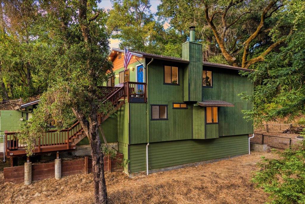 Set in the quiet Quail Hollow neighborhood of Ben Lomond, this inviting home offers a true sense of peace and privacy. Thoughtfully maintained and surrounded by lush greenery, it features a functional layout with great separation of space. The main level is designed to take in natural light and scenic views from nearly every room, including the living room, primary suite, kitchen, and dining area, creating a strong connection to the surrounding landscape. The spacious kitchen includes a large breakfast bar and flows easily into the dining area, with sliding glass doors opening to the front deck, perfect for morning coffee or evening gatherings. Downstairs, two additional bedrooms, a full bath, and an enclosed bonus room offer flexible space for a home office, gym, studio, or extra storage. The flat backyard offers room to garden, play, or simply enjoy the sunshine. A two-car garage, bonus driveway parking, and a dedicated garden area round out the features. Located just minutes from downtown Ben Lomond with easy access to Highway 9 and Zayante Road, this home blends comfort, function, and a tranquil setting, ideal for your next chapter.