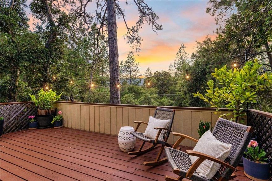Set in the quiet Quail Hollow neighborhood of Ben Lomond, this inviting home offers a true sense of peace and privacy. Thoughtfully maintained and surrounded by lush greenery, it features a functional layout with great separation of space. The main level is designed to take in natural light and scenic views from nearly every room, including the living room, primary suite, kitchen, and dining area, creating a strong connection to the surrounding landscape. The spacious kitchen includes a large breakfast bar and flows easily into the dining area, with sliding glass doors opening to the front deck, perfect for morning coffee or evening gatherings. Downstairs, two additional bedrooms, a full bath, and an enclosed bonus room offer flexible space for a home office, gym, studio, or extra storage. The flat backyard offers room to garden, play, or simply enjoy the sunshine. A two-car garage, bonus driveway parking, and a dedicated garden area round out the features. Located just minutes from downtown Ben Lomond with easy access to Highway 9 and Zayante Road, this home blends comfort, function, and a tranquil setting, ideal for your next chapter.