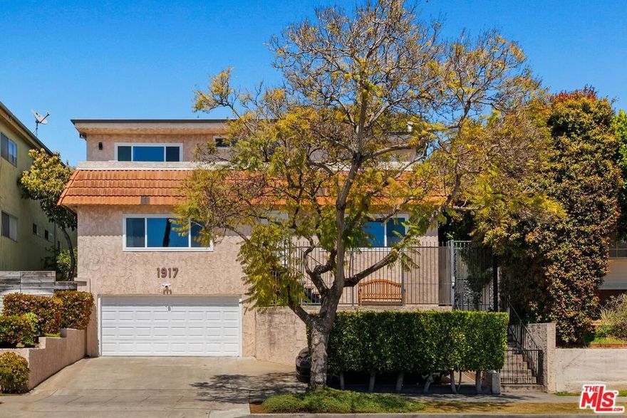 Under a mile from the Pacific, this west-facing front townhome offers approximately 2,300 sq ft of fully rebuilt luxury, featuring 3 bedrooms, 4 bathrooms, and a private driveway with direct access to an attached two-car garage. Inside, a cohesive modern design unites waterproof LVP flooring, white-quartz surfaces, and matte-black accents, enhanced by all-new systems, an upgraded electrical panel, and efficient per-room HVAC cassettes. The entry level includes a private suite with a kitchenette, walk-in closet, and spa-style bath ideal for guests, in-laws, or a separate office setup. The second-floor entertainer's level showcases a dramatic 5'10' quartz island, a 60" Wolf range beneath a custom matte-black hood, Bosch 800 Series appliances, a generous pull-out pantry, and seamless white-on-white quartz backsplash. The sunlit dining and living areas feature a floor-to-ceiling electric fireplace, custom built-ins, and an 83" smart OLED TV. A washer and dryer are also included. On the top floor, two serene primary suites offer designer baths, while the south suite adds a powered office nook, a large walk-in closet, and access to a wrap-around balcony capturing ocean breezes and partial coastal views. Smart-home upgrades include Google/Nest controls, per-room thermostats, smart locks, doorbells and lighting, USB outlets, hard-wired ethernet, in-wall HDMI, and connected appliances. The finished garage provides cabinetry with a quartz worktop, a direct-drive opener with battery backup, and dual EV chargers. MUST SEE!! Showings by appointment only..
