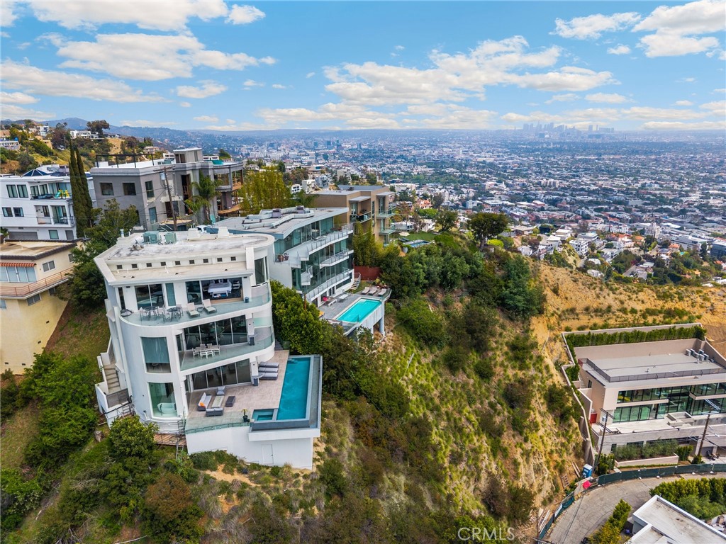 Sitting high atop the world famous Sunset Strip, the first thing you notice when you enter this three bedroom, three and a half bath masterpiece is the breathtaking citywide views of Century City, Hollywood, Palos Verdes and on a clear day; the Pacific Ocean and Catalina Island. Once inside, the incredible amenities are everywhere: Three floors, each with their own private decks and gorgeous views. Miele appliances and Japanese toilets throughout. A built in 65" television with a retractable interface. A high end Savant Home Security System, along with a two car garage. The house is perfect for entertaining and boasts a thumping, high end, club level Home Sound System with Klipsch speakers throughout the entire house. External and internal color lighting system that can be changed with a push of a button. The primary suite is the entire bottom floor and comes complete with a large soaking tub, Tonal workout gym system (membership not included) and elliptical machine, massive walk-in closet and instant access to the stunning infinity pool, hot tub and gas fire pit that overlooks all of Los Angeles. Centrally located in the Hollywood Hills West means easy access to all the countless amenities found in West Hollywood, Beverly Hills, Westwood and the entire Westside.