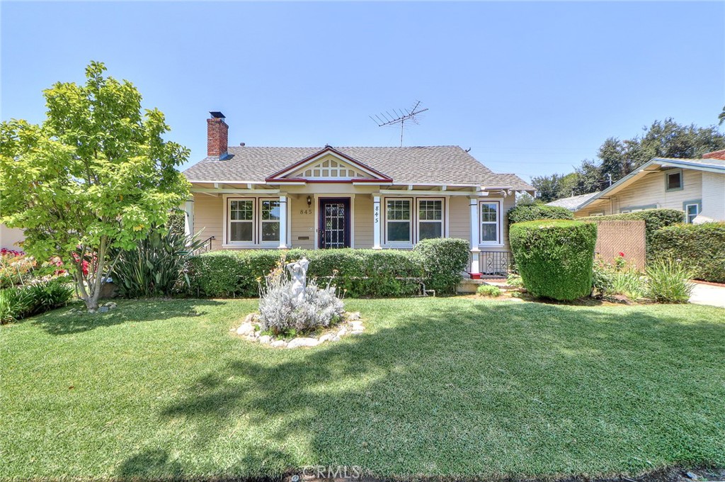 Step into timeless elegance with this beautifully maintained California Craftsman-style home, nestled in one of Alhambra’s most sought-after neighborhoods near South Pasadena and San Marino. From the moment you arrive, you’re welcomed by a lush, manicured front yard bursting with vibrant flowering plants and mature shrubbery setting the tone for the warmth and character that await inside. A charming front porch leads into a traditional interior rich with architectural detail. The living room features original hardwood floors, a brick fireplace with a classic mantle, and custom built-in bookshelves that flow seamlessly into the adjacent dining room, complete with wainscoting and a stunning built-in china cabinet with leaded glass. The full bathroom offers a tub/shower combo with a glass enclosure, vintage tile accents, and a single-sink vanity. The spacious primary bedroom includes a private half bath and a generous cedar-lined walk-in closet, while the second bedroom also features its own cedar-lined walk-in. Additional built-in hallway cabinetry provides extra storage. The kitchen retains its vintage charm with tile countertops and classic cabinetry, and an adjacent laundry room offers even more storage. Dual-pane windows, along with central heating and air conditioning, ensure year-round comfort. Step outside to an expansive backyard oasis featuring a large concrete pad, a detached two-car garage, and an enormous grassy area with planters and walkways perfect for entertaining, gardening, or future ADU potential. The garage is equipped with its own electrical panel, water and gas hookups, utility sink, built-in cabinetry, and a workbench ideal for a workshop or potential conversion.