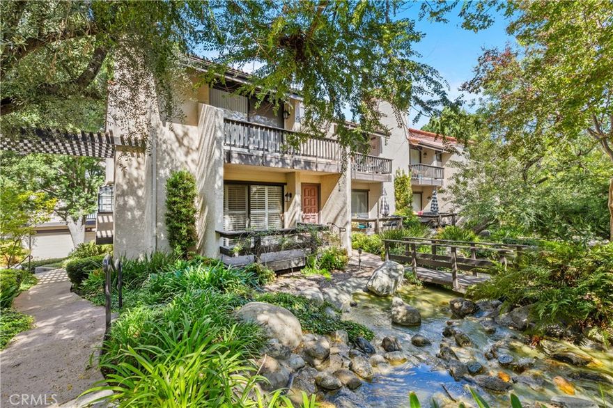 Be the first to enjoy this exquisitely renovated end-unit townhome.This luxury townhouse is ideally situated in a serene interior location in the highly sought-after Warner Village community. Step into a spacious living room featuring a striking floor-to-ceiling brick fireplace and plantation shutters that open to a wood deck overlooking lushly landscaped grounds with tranquil running streams, picturesque bridges, and mature trees, a true garden oasis. The formal dining area boasts elegant wainscoting, a quartz-topped dry bar, and direct access to a charming atrium-style balcony, perfect for indoor-outdoor entertaining. The stunning kitchen has been remodeled with soft-close cabinetry, quartz countertops, a subway tile backsplash, recessed lighting, and newer appliances, including a gas oven with integrated grill cooktop and a built-in microwave. The spacious primary suite features vaulted ceilings, dual closets, a balcony with treetop views, and a beautifully updated en-suite bathroom with quartz counters and sleek modern cabinetry. The secondary bedrooms are light and bright and share a large updated full bathroom. Thoughtful upgrades are found throughout the home, including wide plank white oak engineered wood flooring, plush carpet, luxury vinyl floors, fresh paint, designer fixtures, updated lighting, and more. Enjoy direct access from the attached two-car garage into a versatile bonus room — ideal as a home office, gym, or potential fourth bedroom. The indoor laundry area comes fully equipped with a washer and dryer for added convenience. Warner Village offers peaceful, resort-style living with amenities that include three pools, spas, tennis courts, and lush grounds that feel like a private retreat. Located just across the street from Warner Center Park, where one can enjoy the ever popular “Concerts in the Park” summer series. This unbeatable Woodland Hills location is moments from Costco, The Village, 24 Hour Fitness, fine dining, and top retail. With the new LA Rams Training Facility nearby and the transformative Warner Center 2035 development on the horizon, this is your opportunity to own a beautifully upgraded home in the heart of Woodland Hills — where lifestyle, convenience, and long-term value converge.