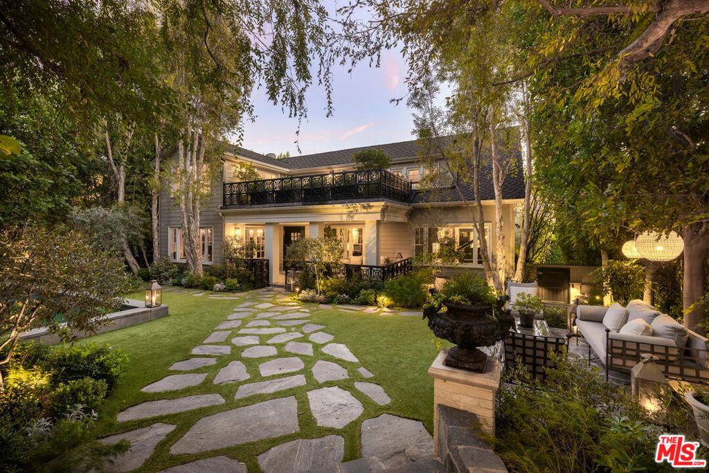 A Hollywood legacy reimagined and steeped in history yet infused with modern luxury, this iconic gated estate, once the residence of legendary filmmaker Preston Sturges, is a masterpiece of design and refinement. Nestled at the base of Runyon Canyon, this private sanctuary spans approximately 7,000 square feet, surrounded by lush hedges and a serene front garden with a reflecting fountain. Step inside and be transported an extraordinary 1,800-square-foot grand room anchors the home, featuring an original antique copper-topped bar, a stately fireplace, and soaring ceilings that evoke the glamour of Hollywood's golden age. The formal dining room sets the stage for unforgettable gatherings, while the chef's kitchen, outfitted with a La Cornue range, invites culinary artistry. A distinguished gentleman's roomwhispered to be the site of Charlie Chaplin's first wedding adds to the home's storied past. Upstairs, the primary suite is a retreat of elegance, complete with a fireplace, spa-like ensuite, and French doors leading to a private rooftop terrace with breathtaking city views. Three additional en-suite guest bedrooms offer private patios, blending comfort with sophistication. An approximately 1,200-square-foot guesthouse with a full kitchen, dining area, laundry, private patio, indoor sauna, and cold plunge completes this rare offering an estate that embodies timeless elegance, rich heritage, and the ultimate in Hollywood living.
