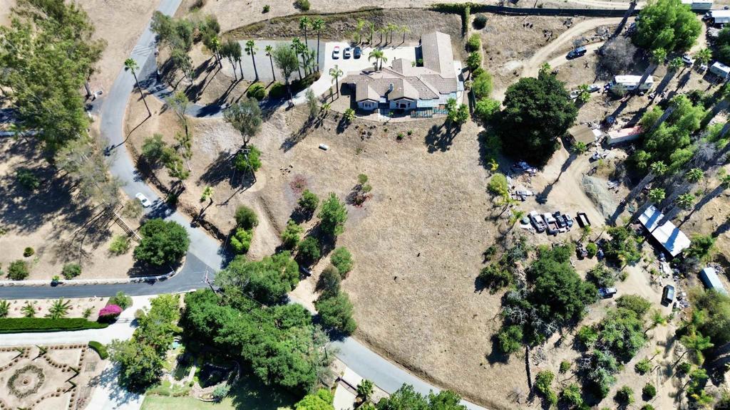 Set on just over 2.55 acres in the Live Oak Park area of Fallbrook, 2749 Los Alisos Dr offers 3,385 sq. ft. of single-level living with plenty of room to make it your own. Built in 2002, the home features 3 bedrooms, 3.5 baths, and a flexible layout with multiple bonus spaces suited for an office, gym, workshop, or library. This is a great starter home that needs minor work to bring the property up to date! Bring your contractor or DIY! The main living area has vaulted ceilings and a fireplace, opening to a large kitchen with granite counters, a center island, and double ovens. The primary suite includes a sitting area and direct patio access, while the secondary bedrooms are located on the opposite wing for privacy. The master bedroom/bathroom has a huge 16'x11' walk in closet. Additional highlights include an attached 3-car garage, central heat and air, fire sprinklers, and a private gated entry. The acreage is horse-friendly and includes a compacted pad with its own septic system—ideal for a workshop or future guest house. This is a mild fixer with strong bones and excellent potential. A few updates will allow the next owner to bring their vision to life and enjoy the space, privacy, and views that make this part of Fallbrook so desirable.