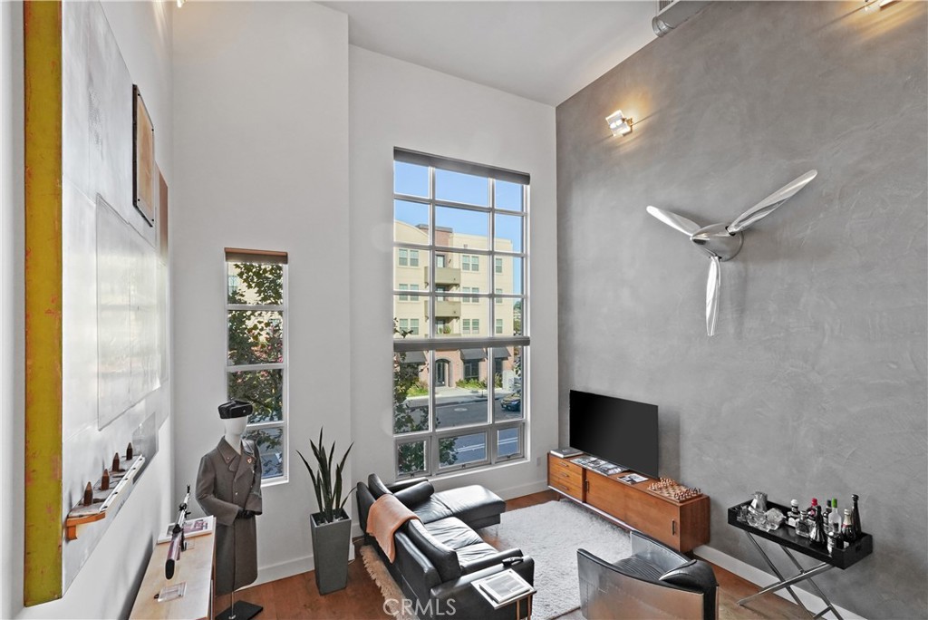 Discover a rare opportunity to own a stunning 1,583 sq. ft. live/work loft in the heart of Santa Ana’s historic French Park community. This contemporary residence blends modern style with flexible functionality, ideal for creatives, entrepreneurs, or anyone seeking an inspiring space to call home. Step inside and you’ll be welcomed by 24-foot ceilings, stunning luxury cement plaster, and dramatic floor-to-ceiling windows that flood the open-concept living room with natural light. The sleek kitchen features stainless steel appliances, rich cabinetry, and a dining area framed by oversized windows—perfect for entertaining or daily living. Hardwood floors flow throughout, adding warmth and sophistication. The loft-style bedroom offers privacy while maintaining the open, airy ambiance, complemented by 1.5 bathrooms with modern finishes. A versatile upper-level space overlooks the main living area, ideal for a home office, studio, or creative retreat. Additional highlights include a two-car tandem garage, direct street access, and rare live/work zoning, allowing you to seamlessly integrate your lifestyle and business. Located in the vibrant French Park district, you’re just steps from Downtown Santa Ana’s award-winning dining at Le Hutt Dinette, 6100 Baker, Hiden House cafés, art galleries, and cultural experiences. This is more than a home—it’s a lifestyle.
