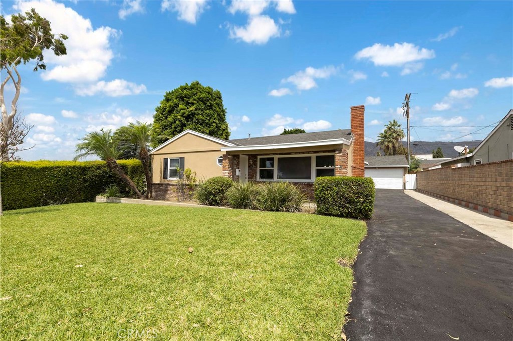 Charming single-level home on a quiet street in the heart of Glendora. A welcoming front porch leads you into this 3-bedroom, 1.5-bathroom floor plan. The bright and spacious living room features a beautiful fireplace, while the kitchen offers classic cabinetry, a cozy dining nook, and a utility area with washer and dryer hookups. Recent updates include a drive way, front door and sliding back door. Outside, enjoy a generous backyard with an open patio, along with a long driveway leading to a detached two-car garage. Ideally located near schools, shopping, and major transportation—this is a wonderful opportunity to own a truly special Glendora home!