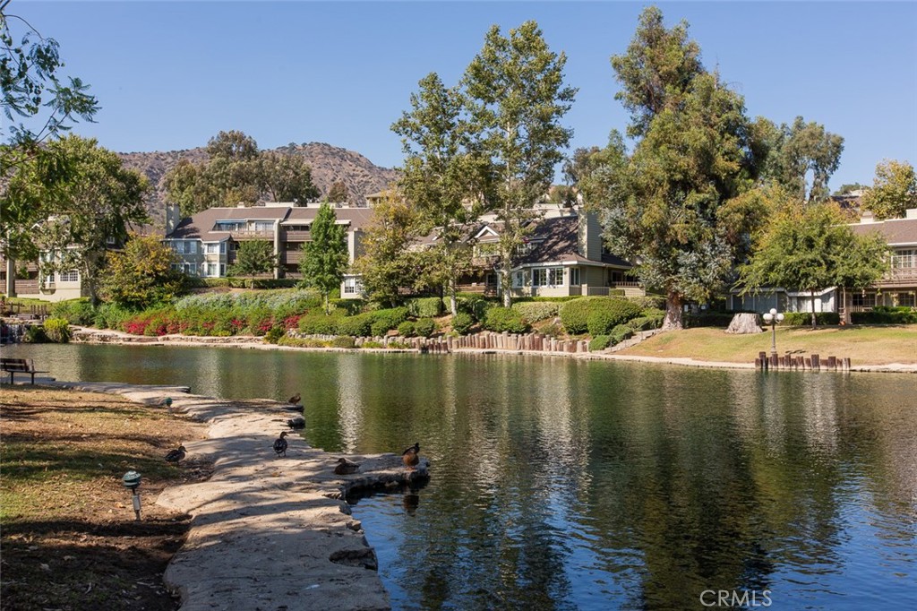 Welcome Home! This wonderful North Azusa Stair Free Condo is in the beautiful, one-of-a-kind Rainbow Lake Community. A secluded gated community with its very own private angling lake. This charming home features 1,347 sqft of living space, 2 bedrooms, 2 full bathrooms, a spacious balcony, a semi-attached 1 car garage and a second 1 car detached garage. This hillside unit has amazing views and plenty of natural light. The unit is ground level; there are no stairs to get in or out of the home. The bathrooms and bedrooms have been recently remodeled. And there is newer flooring throughout the home, as well as newer shutters on the windows. The kitchen features brand new counter-tops & backsplash, wall-to-wall cabinets, newer flooring, a dishwasher, oven and enough space for a small dine-in table. The living room has newer flooring, panoramic views and a lovely gas fireplace. The master bedroom has a large walk-in closet, balcony access and the master bathroom has a huge soaker tub. This is a very clean and move-in ready home in a very charming unique community. Community was just fitted with brand new Fiber Optic cabling. HOA is also in the process of revamping the community with fresh paint too. Hurry up, this one will not be on the market for long.