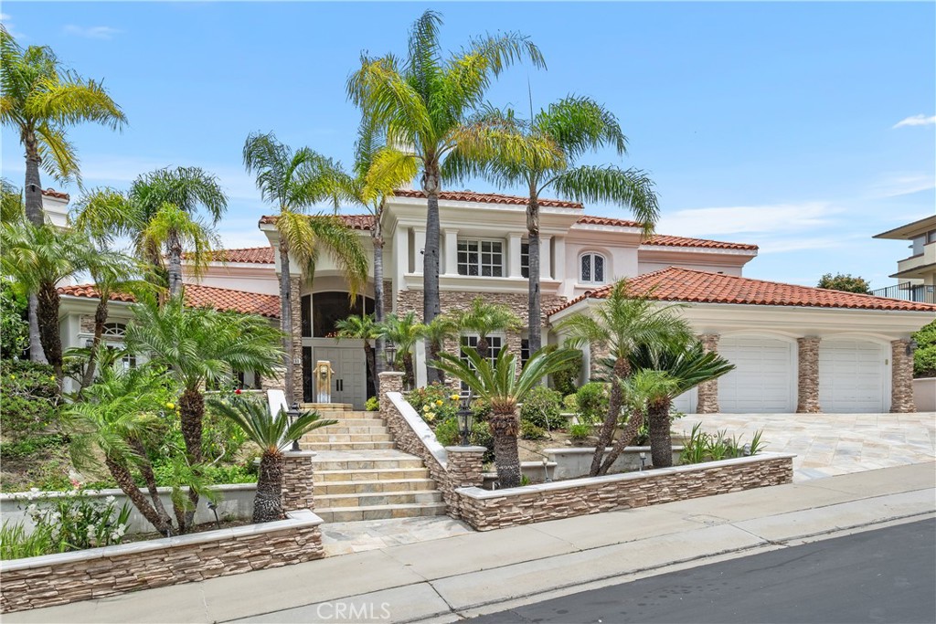 Hillcrest – A Luxurious gated Estate with Breathtaking City and Lake Views. Perched atop a scenic hillside in Orange, CA, Hillcrest offers unparalleled luxury, space and views that will take your breath away. This impressive six-bedroom, six-and-one-half-bathroom estate is designed to maximize its stunning surroundings, boasting expansive vistas of sparkling city lights and the tranquil lake beyond. Four of these spacious rooms are upstairs and two bedrooms and one office are conveniently located downstairs. Head through the grand entrance into a world of sophistication, where soaring ceilings and elegant finishes set the tone for a truly remarkable home. The expansive living spaces seamlessly flow into a chef’s kitchen, complete with top-tier appliances, custom cabinetry, and a generous island—ideal for both everyday living and entertaining. Each bedroom provides a serene retreat, but the primary suite is the true showstopper, offering a spa-like bathroom, walk-in closet and private balcony with mesmerizing views stretching across the skyline and lake. Outside, the resort-style backyard is an entertainer’s dream, featuring multiple terraces, a sparkling swimming pool and ample lounge areas where you can take in the dazzling city lights as they twinkle below. Whether sipping coffee at sunrise or enjoying an evening gathering under the stars, Hillcrest’s breathtaking backdrop makes every moment extraordinary. Conveniently located near premier shopping, dining, top-rated schools and major freeways, this estate seamlessly combines luxury, comfort, and an unbeatable location. Don’t miss the chance to call Hillcrest home—schedule a private tour today!
