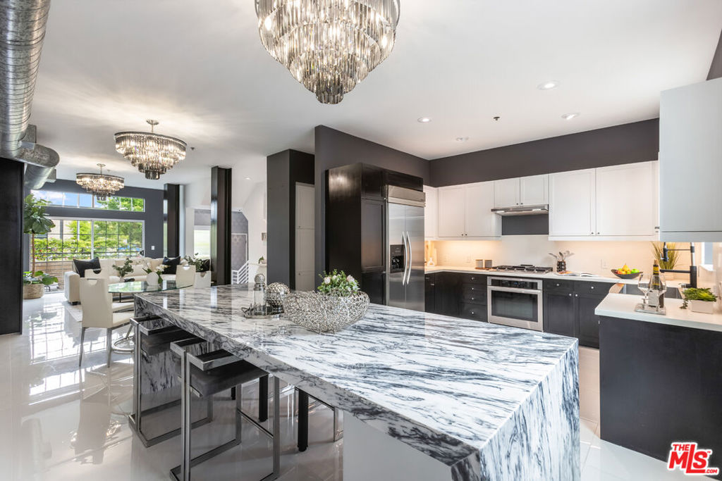 Step into this stunning completely renovated townhome, refinished with premium materials throughout and ideally located on a charming walk street in the highly sought-after Bridgeway Mills community of Playa Vista. Boasting over 2,000 square feet of thoughtfully designed living space, this 2-bedroom + den, 2.5-bath tri-level residence offers the perfect blend of sophistication, comfort, and functionality. From the moment you enter, you're greeted by beautiful porcelain tile and expansive windows that flood the home with natural light. The open-concept main level seamlessly connects the stylish kitchen, dining area, and living room perfect for entertaining or everyday living. The chef's kitchen features sleek light cabinetry, marble island, quartz, countertops, stainless steel appliances, and a generous island ideal for casual dining.Designed for effortless indoor-outdoor living, this home includes an expansive ground-level patio, as well as a spectacular third-floor deck with sweeping views of the city.Upstairs, the second level offers a spacious bedroom, a full bath, and a versatile loft/den/office space. The entire third floor is dedicated to the expansive primary suite, featuring a spa-like bathroom with dual vanities, a soaking tub, walk-in shower, and a large walk-in closet.Additional highlights include a rare attached 3-car garage with ample storage and 220V EV charging capabilities. Located just blocks from Playa Vista Elementary and the public library, and minutes from Runway at Playa Vista, Whole Foods, Cinemark, and a variety of trendy restaurants and boutique shops. Residents enjoy exclusive access to two state-of-the-art fitness centers, each with resort-style pools. This is a rare opportunity to own a true gem in the heart of Playa Vista.