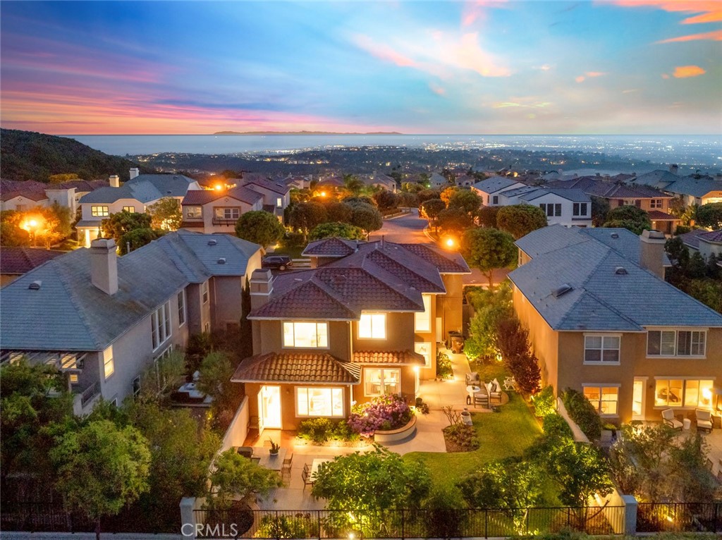 Located within the prestigious gated community of Campobello, this beautifully upgraded residence is being offered for the first time since its original construction and offers an ideal blend of space, comfort, and coastal charm. Spanning approximately 2,762 square feet, the home makes a striking first impression with soaring 18-foot ceilings and an abundance of natural light.
The open-concept layout flows effortlessly from the formal living room to the dining area, while the updated kitchen, with quartzite natural stone counters, a Wolf cooktop, double ovens, stainless steel appliances, and soft-close cabinetry, opens to a spacious family room with a cozy fireplace, perfect for everyday living and entertaining. The backyard is equally inviting, featuring a built-in BBQ area and ample space to relax or gather with friends.
A desirable main-level bedroom with French doors opens to the gated front patio, perfect as a guest suite, home office, or multi-generational space. Upstairs, three generously sized bedrooms include a luxurious Master/primary suite with a spa-inspired bath featuring a standalone soaking tub, separate shower, and a large walk-in closet. The two upstairs secondary bedrooms and the downstairs bedroom enjoy corridor, peek-ocean, and city light views.
Additional highlights include quartz countertops in the bathrooms, custom tile work, and access to Campobello’s private pool and spa. Residents also enjoy Newport Coast Master Association amenities, including a Junior Olympic pool, spa, clubhouse, BBQ areas, tennis, pickleball, basketball courts, and expansive parks and playgrounds. Moments to 1,000s of acres of CA state protected land with scenic hiking and biking trails, sports park, Fashion Island, freeway access, award willing schools, and world class beaches, live the good life that Newport Coast has to offer.