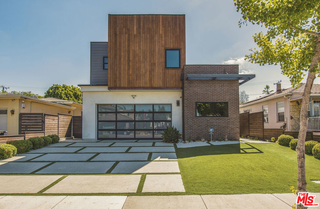 Stunning modern architectural home on one of Sunset Park's most coveted tree-lined streets. This thoughtfully designed Santa Monica residence blends indoor-outdoor living with high-end style. Step through a striking stone wall entry and commercial-grade glass doors into an expansive great room with double-height ceilings, fireplace, custom sectional, work space, and surround sound. The backyard is an entertainer's paradise, featuring a 35-ft saltwater pool with waterfall, jacuzzi spa, Iroko wood dining table, two patios with firepits, designer grill by Daniel Germani, and vibrant Moroso furniture.The sleek chef's kitchen boasts a 12-ft Dekton island, Viking appliances, and a walk-in pantry. A floating glass staircase leads to a loft landing, four en-suite bedrooms, and a laundry room. The primary suite offers treetop views, ocean breezes, a spa-like bath with soaking tub, wet room shower, and dual vanities. Additional features include a bonus room ideal for gym or office, chic powder room with Warhol wallpaper, 2-car garage with EV charger, and ample storage. Prime location near parks, dining, Whole Foods, Erewhon, Main Street, and the beach.