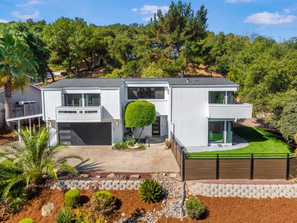 Discover this 1974 sf tri-level retreat on a 9600 sf lot, offering privacy and stunning east mountain views! Ideal for hosting, the open-concept layout boasts a formal dining room, breakfast nook, family room with custom shelves and gas fireplace, plus a separate living room with hardwood floors and wood-burning fireplace. Both feature floor-to-ceiling stone. Upstairs, find 3 bedrooms, 2 updated baths with Satori Statuario Marble-look tile, a versatile loft for an office or playroom, and a laundry room. The primary suite shines with a walk-in closet, soaking tub, and access to a wrap-around balcony for sunrise coffee. Two bedrooms share a second balcony. Six sliders throughout offer access to the balconies and backyard, including a 40-foot pergola and composite wrap-around deck - your private sanctuary! Upgrades include owned solar, Milgard Tuscany windows, large Renewal by Andersen windows in the loft, new appliances, contemporary garage/front doors, and added storage (walk-in closet, 2nd closet, Tuff Shed). The shaded driveway fits 6 cars, elevated for privacy. High ceilings, new siding, fences, new exterior paint, and all 2.5 updated baths enhance this haven. No neighbor windows peering in - pure serenity! Come see your future home and feel the warmth of this inviting retreat!