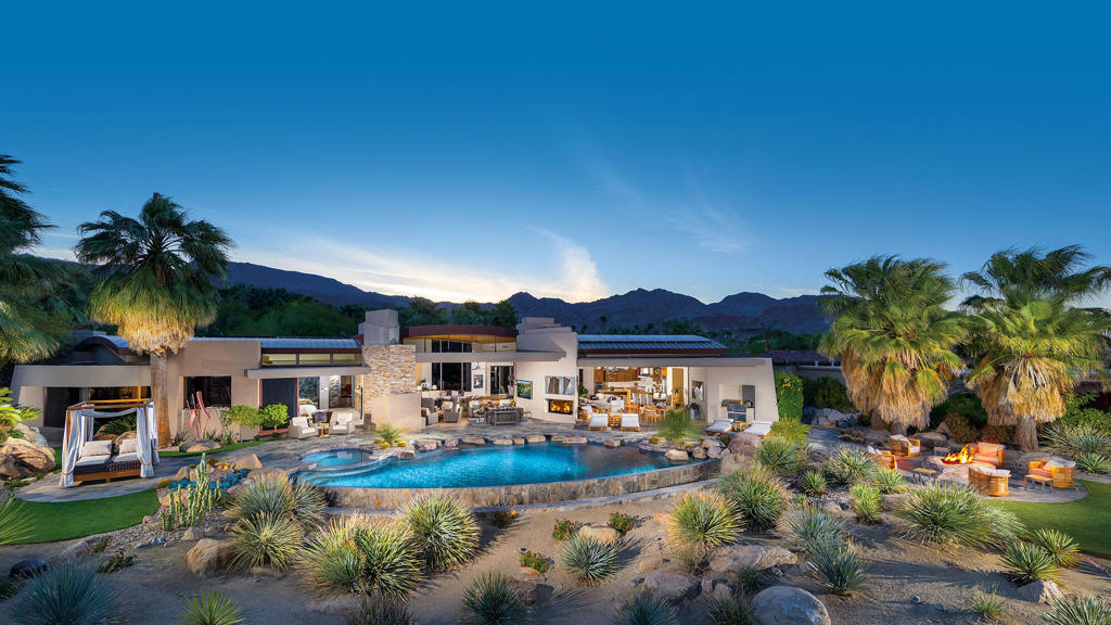Desert living at its finest. Unequalled Outdoor Living with two fireplaces, TVs, sunbather's deck, fire pit, artificial turf, indoor/outdoor bar, infinity-edge pool, spa, outdoor dining and barbecue center with unobstructed views of the green, fairway, waterfalls and Eisenhower Peak. One of four custom barrel ceilings is featured at the main entry and frames a contemporary Living Room, with dramatic fireplace, step-down bar and pocketing walls of glass; open to dining room, family room and outdoor. A large breakfast island with bar seating, high-gloss cabinetry and custom accent lighting, professional-grade appliances, family dining area and spacious family room with fireplace. Master Suite with designer furnishings and finishes, fireplace and TV; spa-inspire bath includes morning bar, dual vanities, soaking tub, shower, boutique-style closets, washer and dryer; direct access to spa and outdoor patio. Attached Guest Wing accessed from inside or outside of the main residence with three separate suites with built-in media, full baths, closets and access to private patios; shared living room with powder bath, fireplace and TV; kitchenette with breakfast seating and outdoor patio. Home Theater with interactive seating, acoustic wall treatments, custom lighting, 'night sky' ceiling, snack bars, refrigerators, icemaker, dishwasher; Home Gym and powder bath. One-of-a-kind finished air-conditioned garage with bar, extensive storage; six fireplaces; professionally furnished.