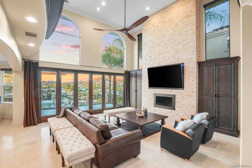 PAID SOLAR & BRAND NEW DOCK WITH LIFT...This stunning East Bay waterfront home truly has it all—impeccably maintained and thoughtfully designed to capture panoramic lake views. Step through the grand entrance and be immediately impressed by a sweeping curved wrought iron staircase and breathtaking views of the lake the moment you walk in.  Enjoy seamless indoor/outdoor living with La Cantina doors that open to a spacious patio, sparkling pool (with new paid solar), and the lake just beyond—perfect for entertaining or relaxing in style. Each level features its own private deck with ceiling fans for year-round comfort.  The open-concept layout includes a main-level primary suite, an executive office, and a state-of-the-art home theater that rivals any cinema. Currently configured as 3 bedrooms plus an office and theater, the home can easily convert back to a 5-bedroom layout. Step outside to your own private dock—brand new and valued at $80,000—complete with a roof and hydro lift for effortless boating.  Located in the exclusive Canyon Lake community, residents enjoy private lake access for boating, fishing, wakeboarding, and waterskiing. Additional amenities include parks, beaches, a scenic 18-hole golf course, lakefront clubhouse dining, junior Olympic-sized pool, tennis and pickleball courts, lakeside camping, and year-round community events. Golf cart-friendly streets make accessing it all a breeze.  Live the ultimate lakefront lifestyle—this exceptional home delivers luxury, comfort, and unforgettable views on every level.