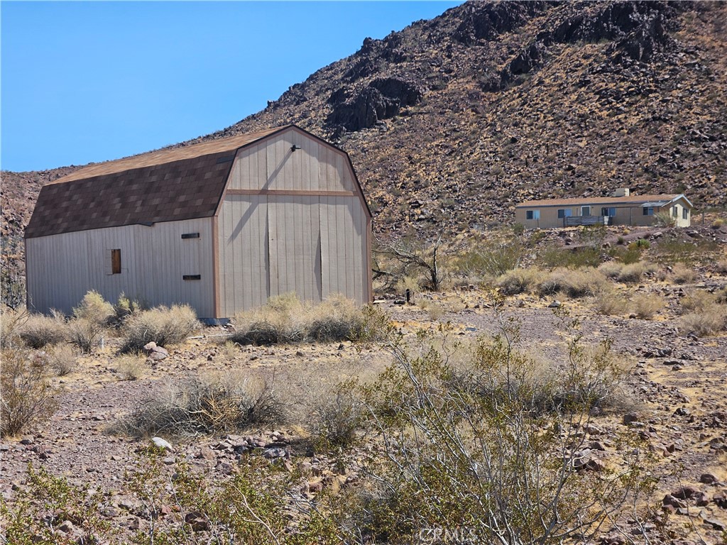 Majestic Mountain Retreat with Sweeping Views
Escape to peace, privacy, and unmatched views with this 3-bedroom, 2-bath manufactured home on 9.66 fully fenced acres. This property offers panoramic vistas of rugged ranges and passing trains — a view arguably the best in all of Newberry Springs.
Your backyard is the mountain itself, providing a dramatic and mysterious backdrop. At the front of the property, a stocked pond with a solar pump adds to the natural charm, while Bighorn Sheep are sometimes spotted roaming nearby. With underground internet access, you can stay connected while enjoying wide-open skies and quiet surroundings.
The home features 1,344 sq. ft., a split floor plan, and indoor laundry. An oversized shed offers extra space for storage or projects, ideal for those who value self-sufficiency and room to create.
Only 20 miles from the city, this private retreat delivers true solitude without losing access to modern conveniences. While the home could use a handy touch, it’s a rare chance to claim a one-of-a-kind property surrounded by untamed nature and breathtaking scenery.
