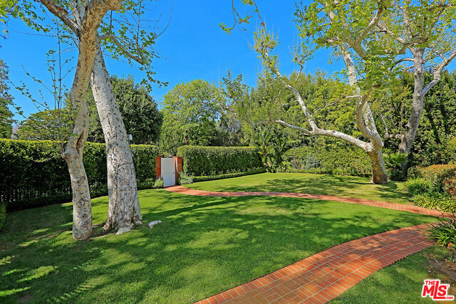 Extraordinary Brentwood Estate situated on a gorgeous 19,560 sq. ft. flat lot in a coveted location. Formerly celebrity owned, this property features a charming single story traditional that is nestled behind a lush hedge which offers complete privacy. Originally built in the 1930s, it has been tastefully updated. Hardwood floors, crown mouldings, vaulted ceilings and custom built-ins, adorn the interior. The kitchen features top of the line appliances, granite counter tops & custom cabinetry. French doors open to an expansive yard equipped with a patio, pool, pool house and a bonus room that is perfect for a gym or office. This is a great opportunity to live amongst world famous celebrities in a nice house on an amazing lot.